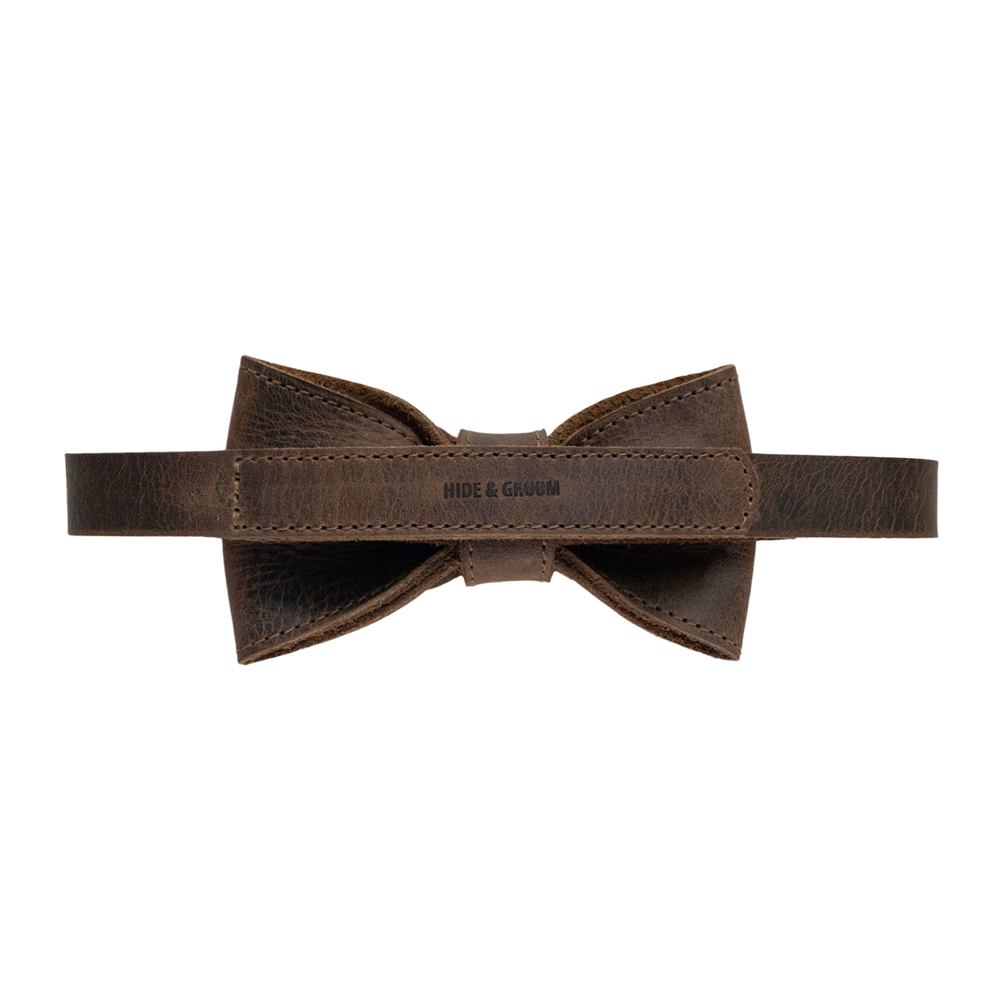 Back view of the Pointed Bow Tie for Groomsmen by Hide & Groom with a clear brand label, emphasizing the hand-sewn finish in full grain leather. This artisan-made bow tie is ideal for formal occasions, blending style and durability for discerning men, embodying small batch production from La Antigua Guatemala & Oaxaca Mexico.