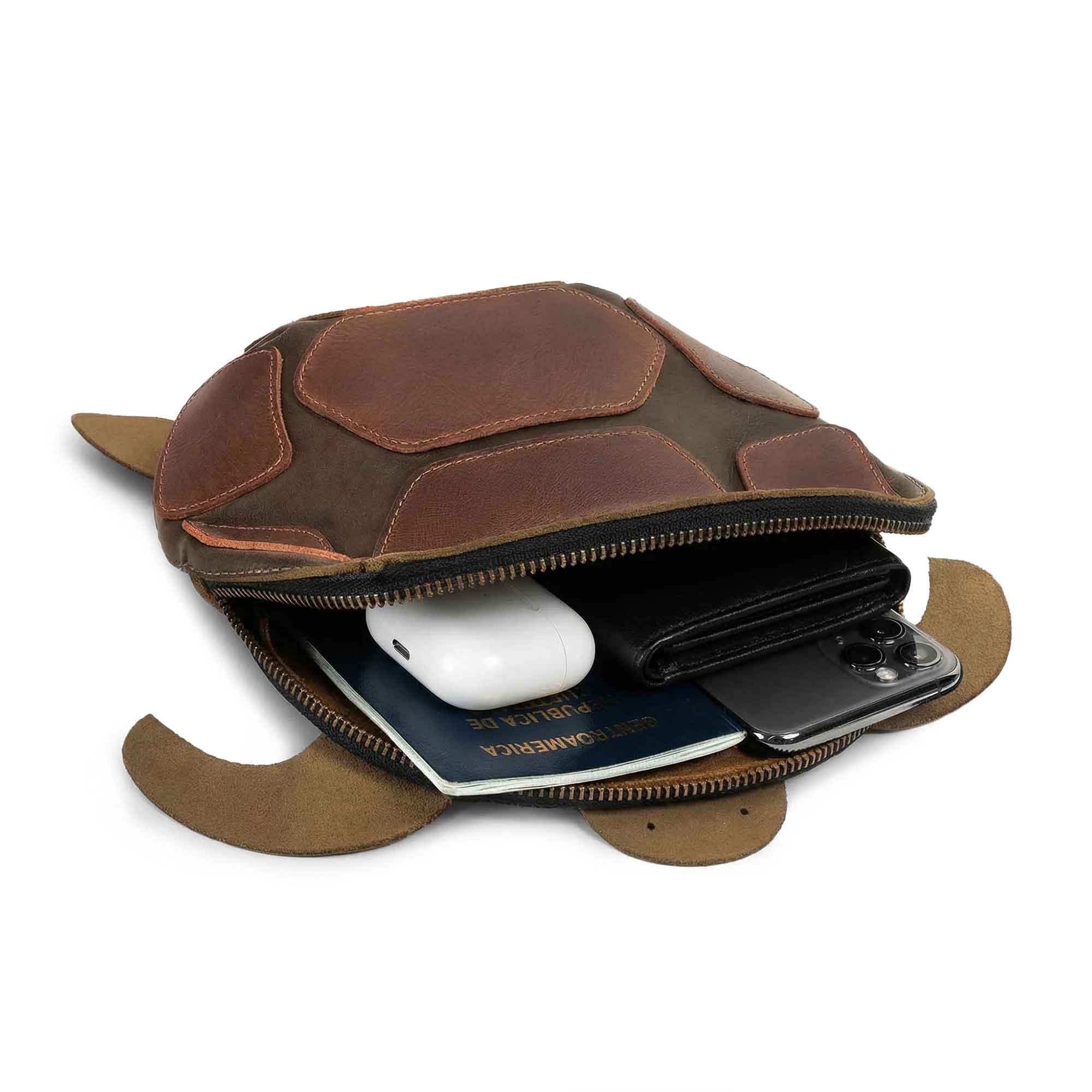 Open view of the Leather Turtle-Shaped Crossbody Bag by Hide & Play, showcasing its spacious interior to hold essentials. This turtle-inspired messenger bag is made of full grain leather, perfect as a travel backpack. Handcrafted in La Antigua Guatemala & Oaxaca Mexico, it features hand cut, hand sewn, and fire branded details.