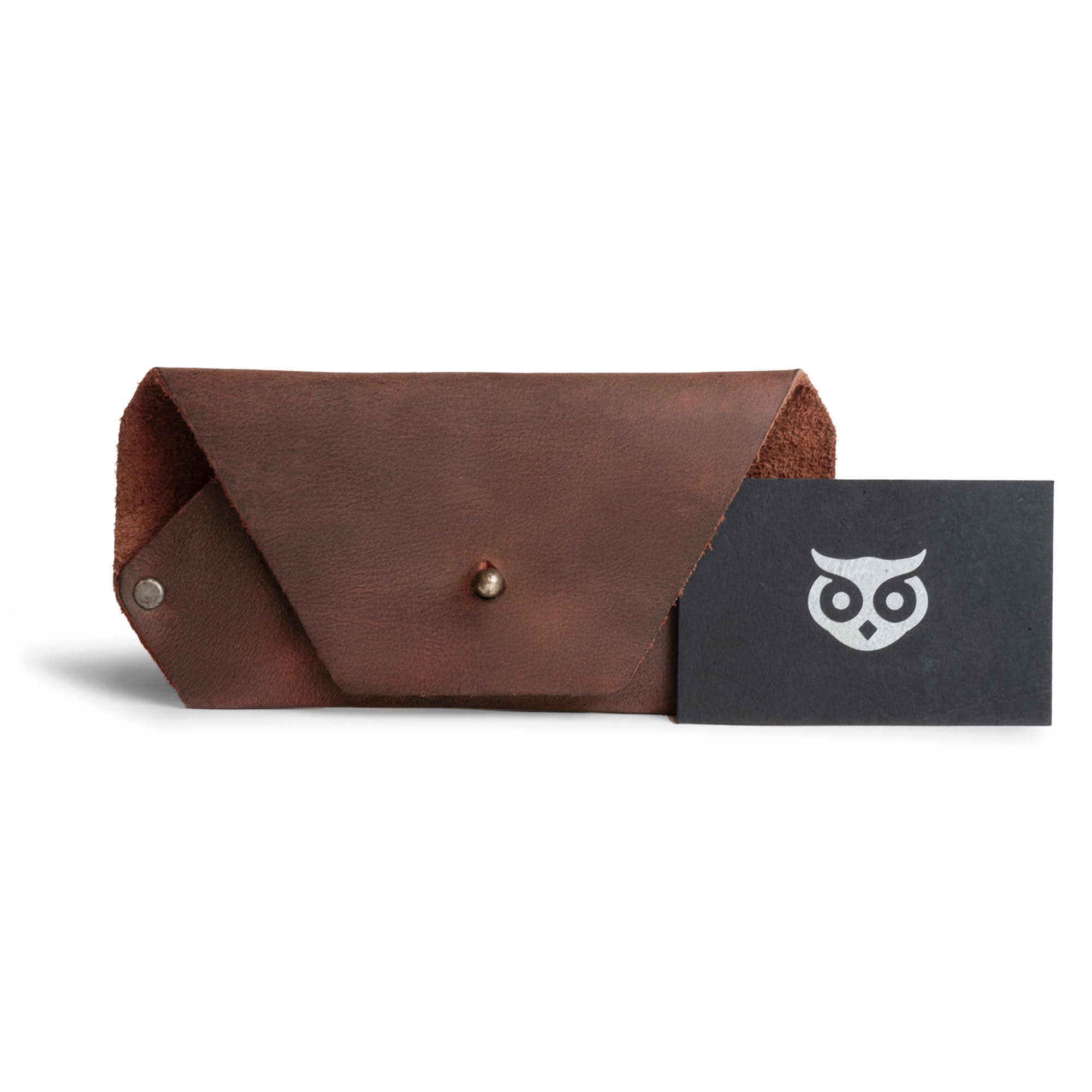 The Sunglasses Sleeve by Hide & Drink, presented alongside a business card, emphasizes the sleek design of this minimalist sleeve case protector for eyewear. Ideal for sunglasses, it showcases full grain leather craftsmanship, perfect for outdoor adventures and travel. Highlighting artisan techniques, the sleeve features small batch production, hand cut, hand sewn methods, and fire branded details, crafted in La Antigua Guatemala.