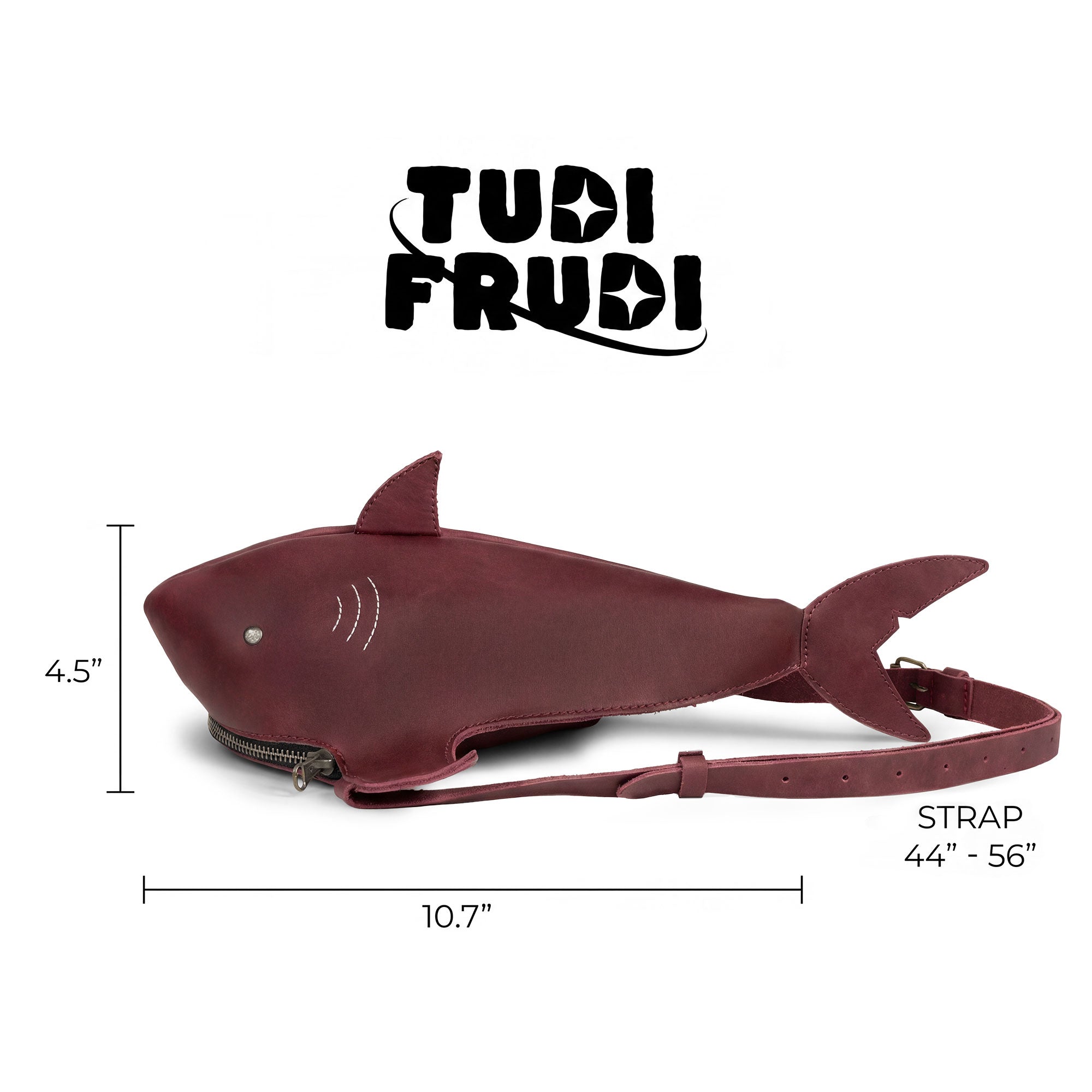 Dimensions of the Shark-Shaped Shoulder Bag by Tudi Frudi displayed alongside branding, highlighting its handmade quality. The bag features an adjustable strap and is crafted from Full Grain Leather, embodying small batch production and artisan handwork from La Antigua Guatemala.