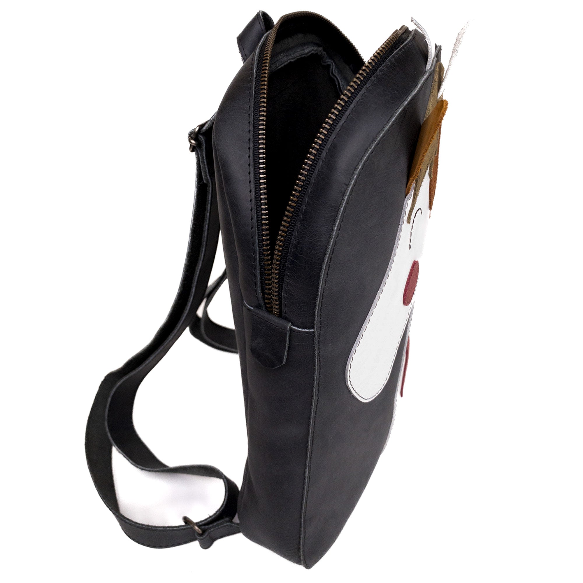 Detail of the side view of the Hide & Play Daily Backpack with Unicorn Design, emphasizing its unique profile and high-quality full grain leather. This stylish casual bag functions as both a messenger bag and a travel bag for men and women. Handmade in La Antigua Guatemala, this backpack showcases artisan techniques like hand cutting and hand sewing, ensuring top-notch quality.