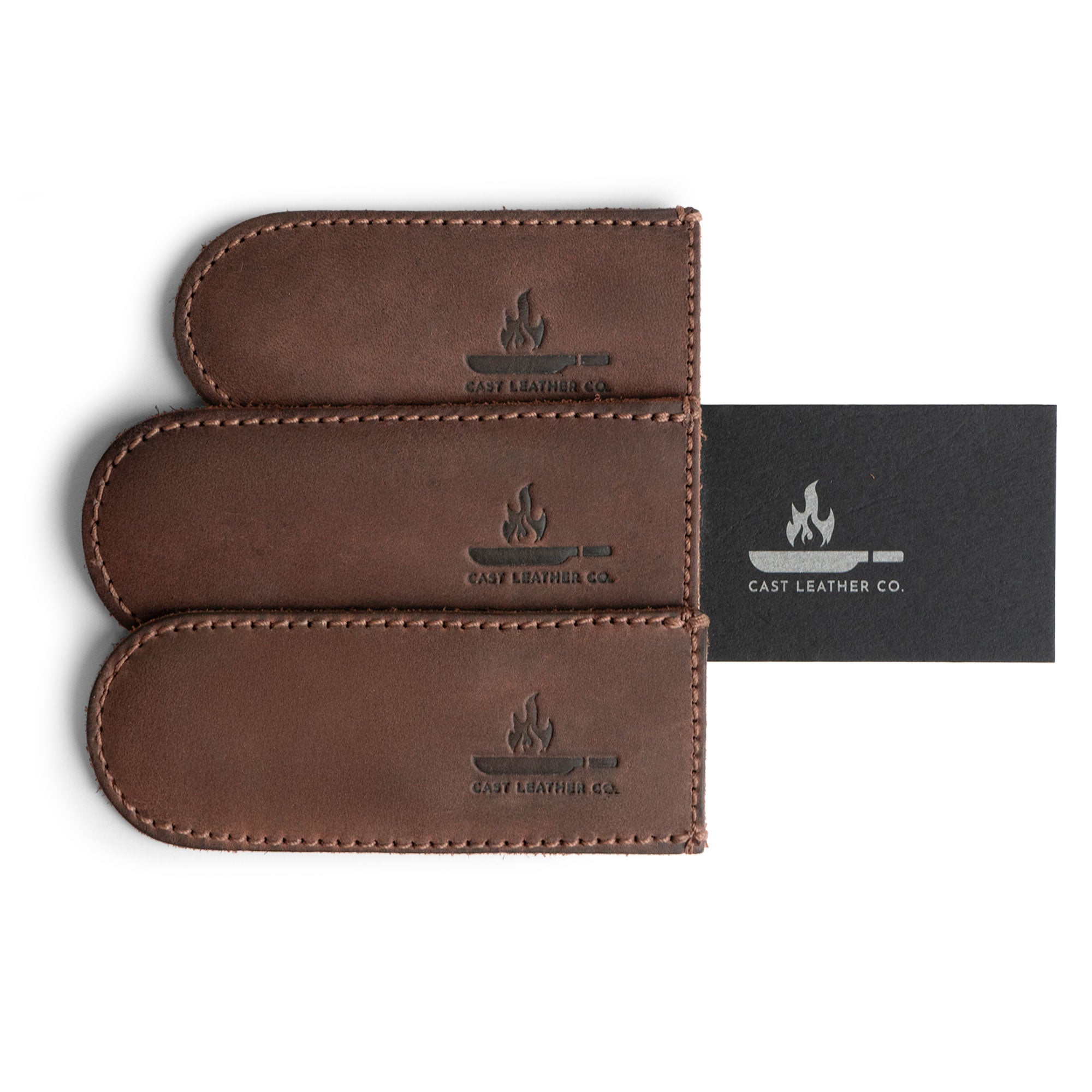 An overview of Cast Leather Co.'s Hot Handle Covers (Set of 3) elegantly packaged, showing their full grain leather finish. These handmade skillet handle covers provide excellent heat resistance and are perfect as a unique gift, reflecting the art of small batch production.