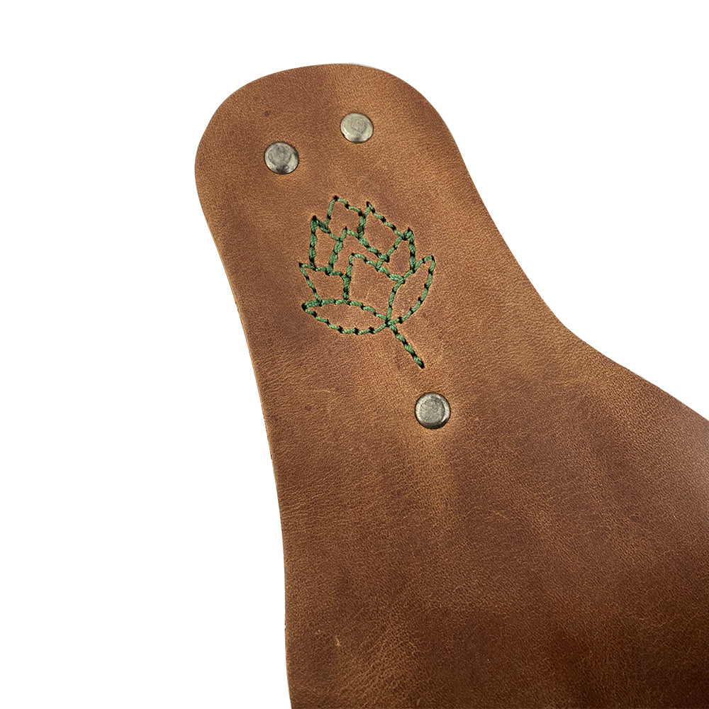 Close-up of the unique stitching detail on the Beer Holster Stitched Designs by Hide & Drink, featuring a decorative leaf pattern. This artisan handcrafted Beer Holster for Cowboy serves as a stylish handsfree beverage holder ideal for men and women, made from durable Full Grain Leather, highlighting small batch production with meticulous hand cut and hand sewn craftsmanship. Produced in La Antigua Guatemala & Oaxaca Mexico.