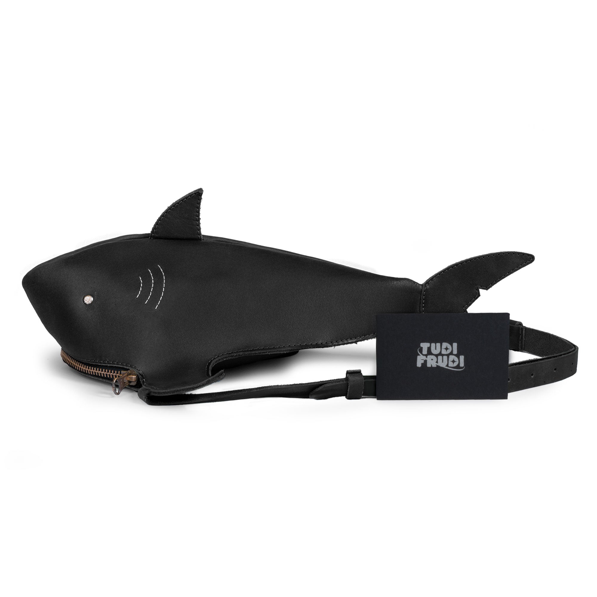 Shark-Shaped Shoulder Bag by Tudi Frudi with branding tag, showcasing its unique shark shape and artisan craftsmanship. This Full Grain Leather bag is a blend of function and style, perfect as a Crossbody or Messenger Bag, made in small batches in La Antigua Guatemala.