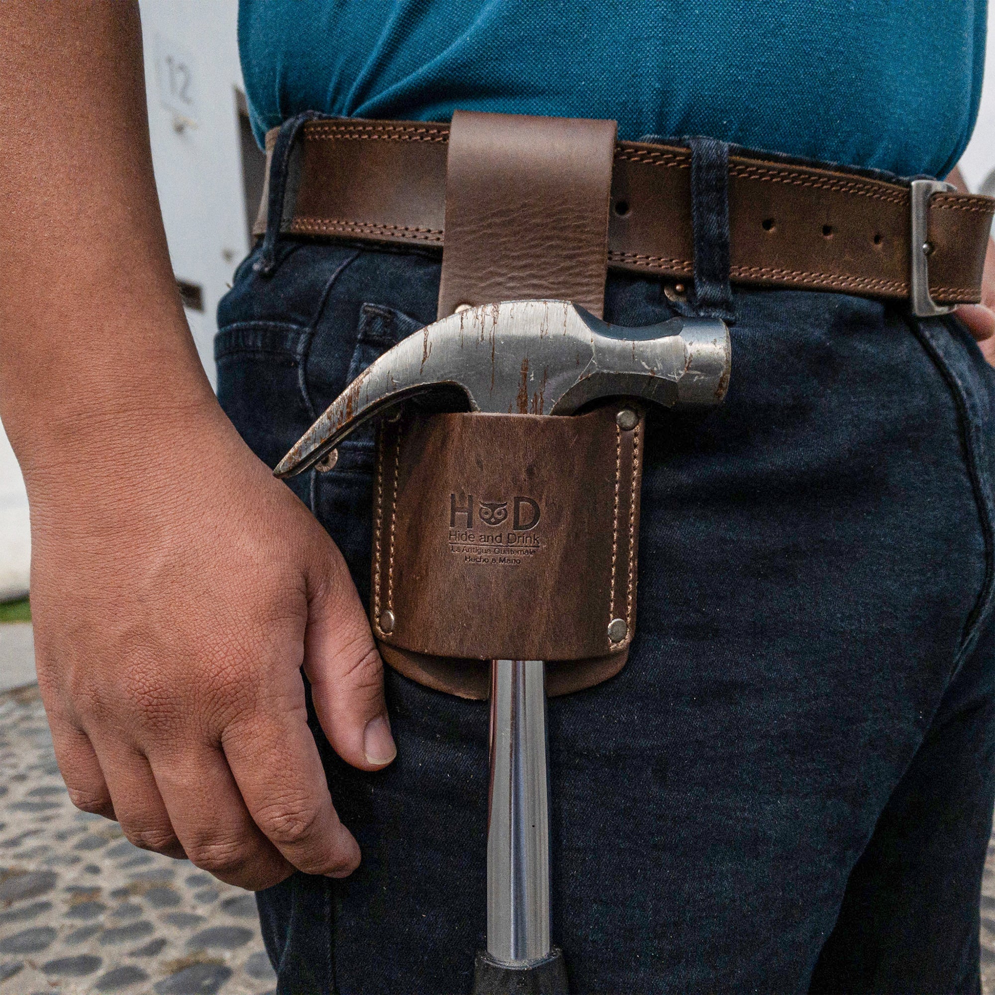 Hammer Holster by Hide & Drink worn on a belt, showcasing its practical use for electricians and construction workers. The soft Full Grain Leather adds comfort and style, making it an essential tool organizer. Hammer Holster - Electrician & Construction, Tool Holder, Organizer, Sheath, Case, Woodwork & Handcraft, Full Grain Leather, StockyardX, Small Batch Production, Hand Cut, Hand Sewn, Fire Branded, Artisan, Handmade in La Antigua Guatemala & Oaxaca Mexico.