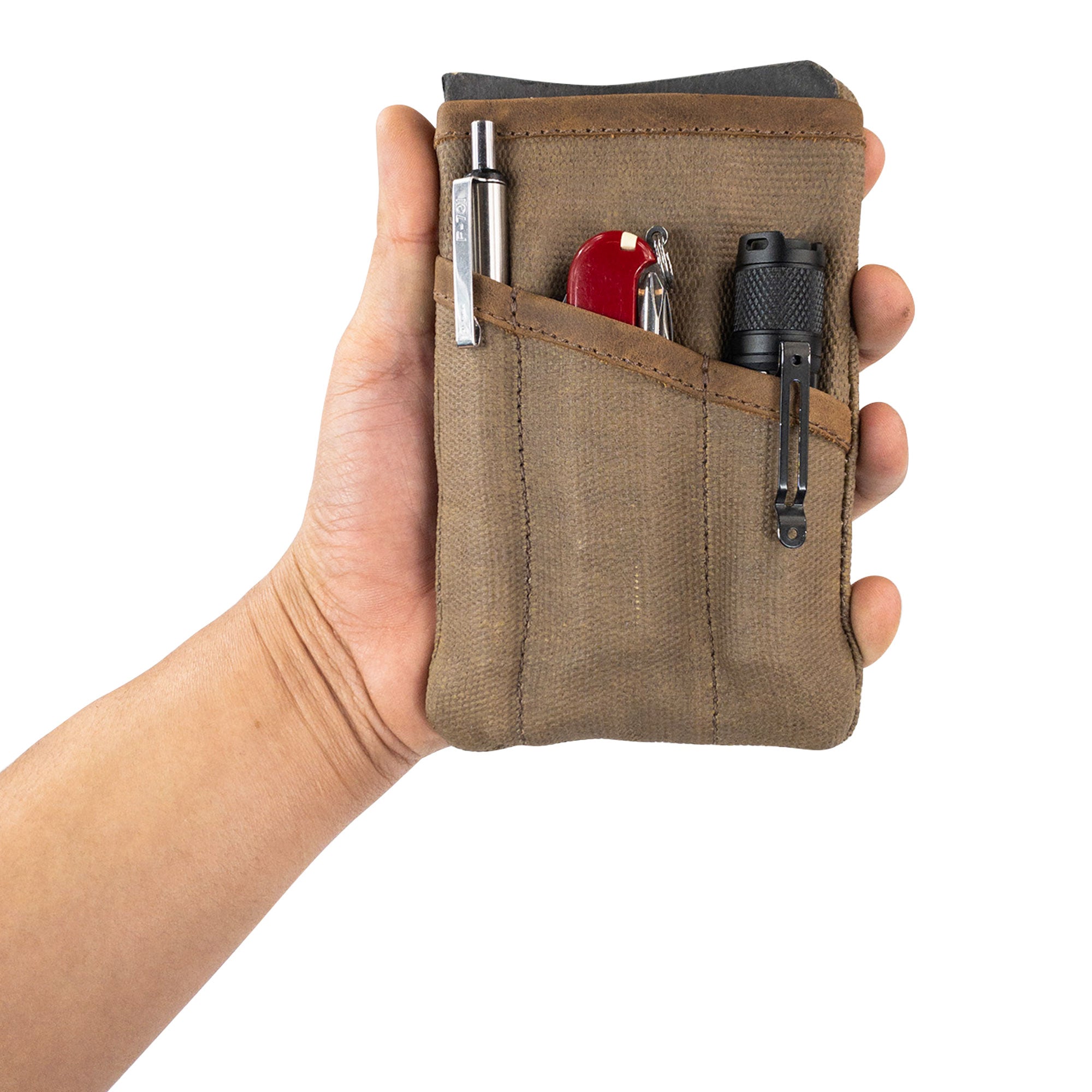 Person holding the Multi-tool Pocket Pouch by Hide & Drink, showing its sleek and slim profile, perfect for easy carrying as a knife holster and organizer.