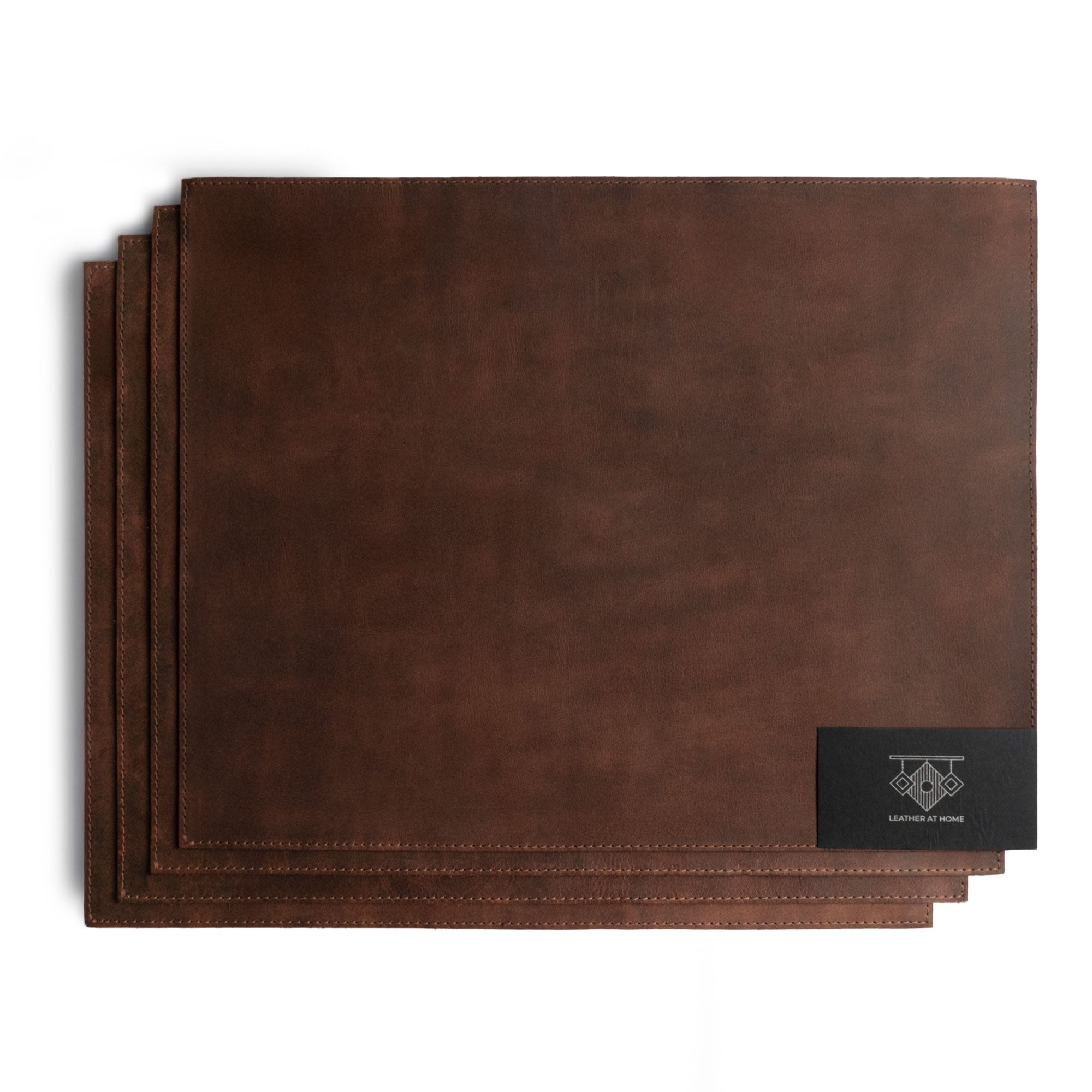 Set of 4 Rectangular Place Mats by Leather At Home, highlighting a refined collection of genuine full grain leather placemats. These rustic mats emphasize the handmade production process, including fire branding and artisan craftsmanship made in La Antigua Guatemala & Oaxaca Mexico.