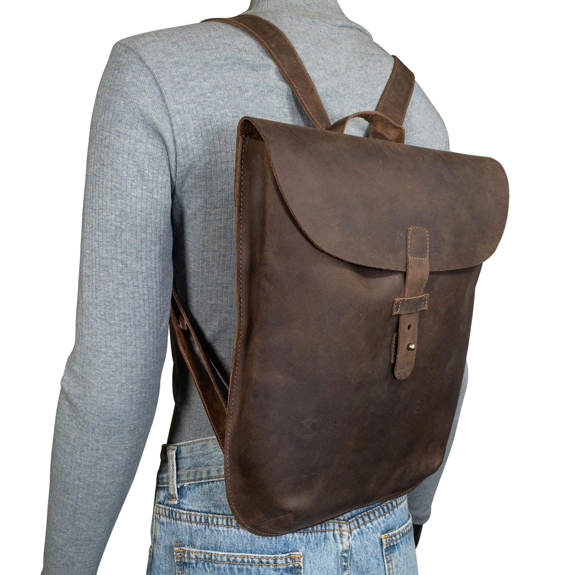 Model wearing Hide & Drink's Rounded Laptop Backpack with Adjustable Straps. This stylish full grain leather backpack serves as a portable case and travel accessory. Handmade in La Antigua Guatemala & Oaxaca Mexico, showcasing a blend of comfort and artisan craftsmanship.