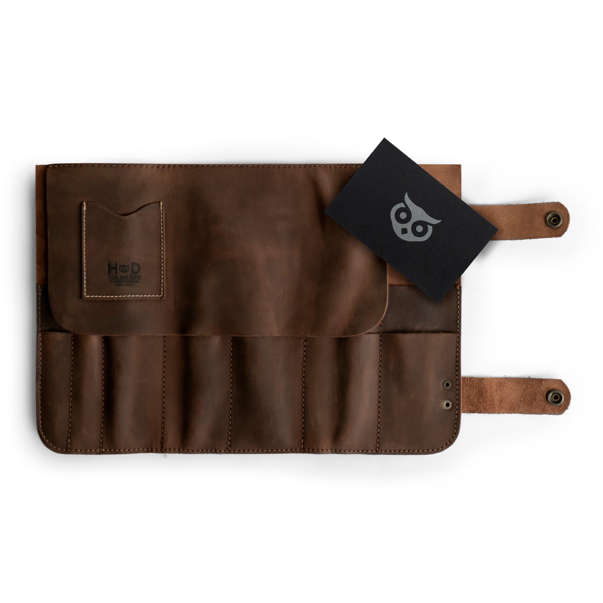 Hide & Drink presents its Barber Tool Roll, showcasing a Snap Tool Roll Up Bag with 14 Slots. Ideal for your scissors & screwdrivers, this portable carry case is crafted from durable Full Grain Leather, reflecting StockyardX's commitment to small batch production, artisan craftsmanship, hand cut, hand sewn, and fire branded in La Antigua Guatemala & Oaxaca Mexico.