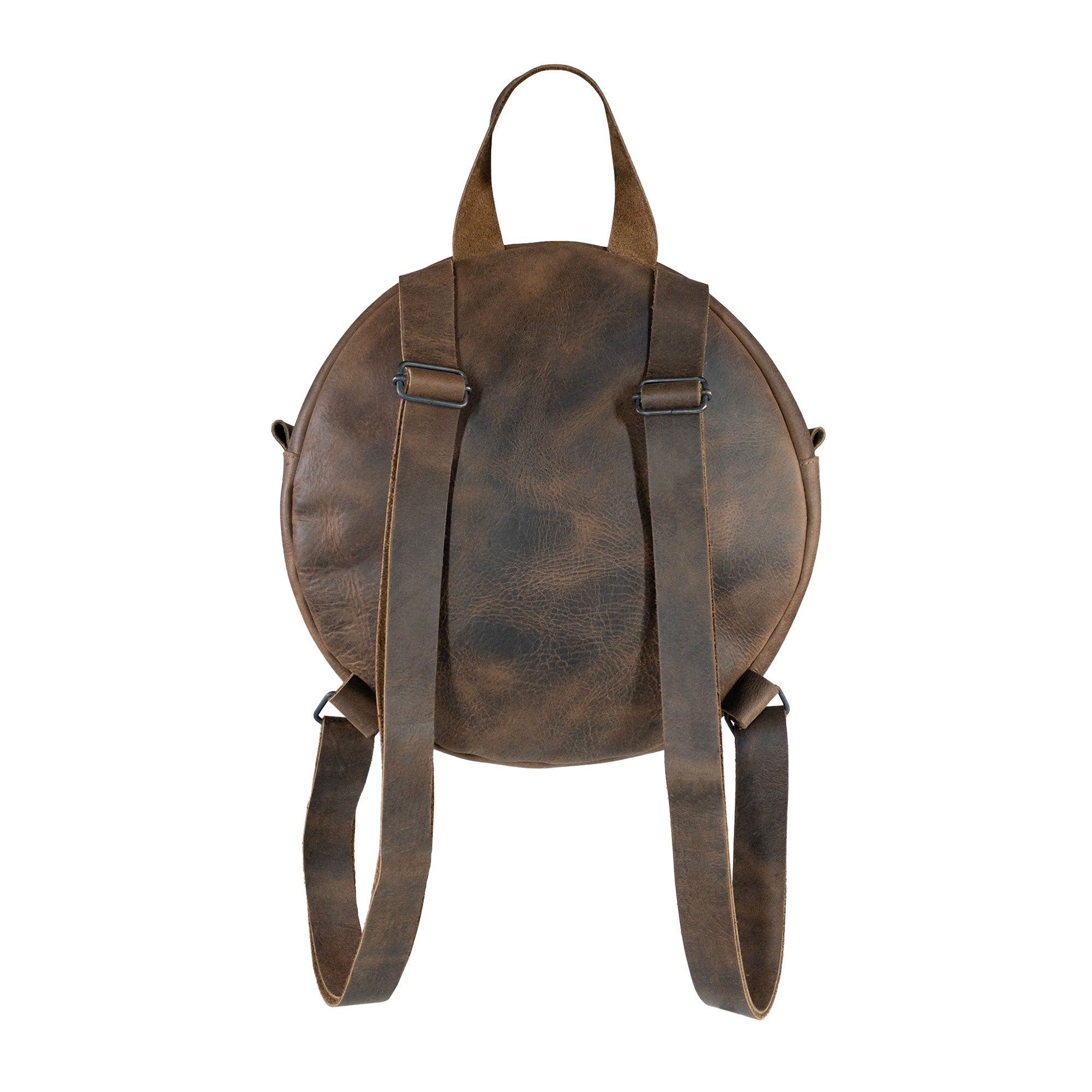 Back view of Heather's Circular Backpack highlighting the structured round shape in rich full grain leather. This travel accessory doubles as a casual daypack and features adjustable straps, showcasing the artistry of hand cut and hand sewn details by artisans in La Antigua Guatemala & Oaxaca Mexico.