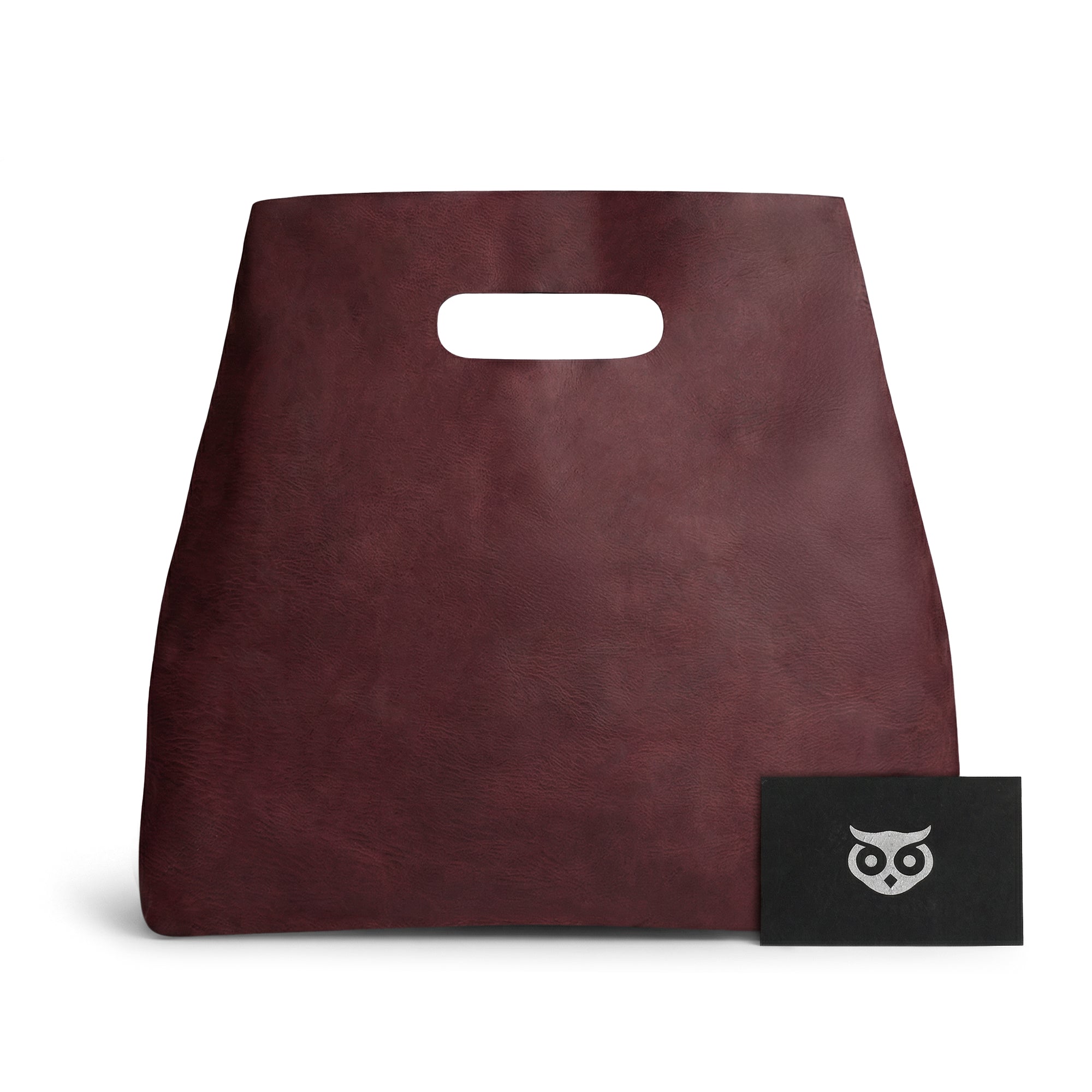 The front view of the red Minimalist Boho Handbag from Hide & Drink, adorned with a stylish card. This Minimalist Handbag for Women acts as a sophisticated Rustic Purse, made from durable Full Grain Leather, reflecting StockyardX's artisan values in Small Batch Production and superb craftsmanship from La Antigua Guatemala & Oaxaca Mexico.