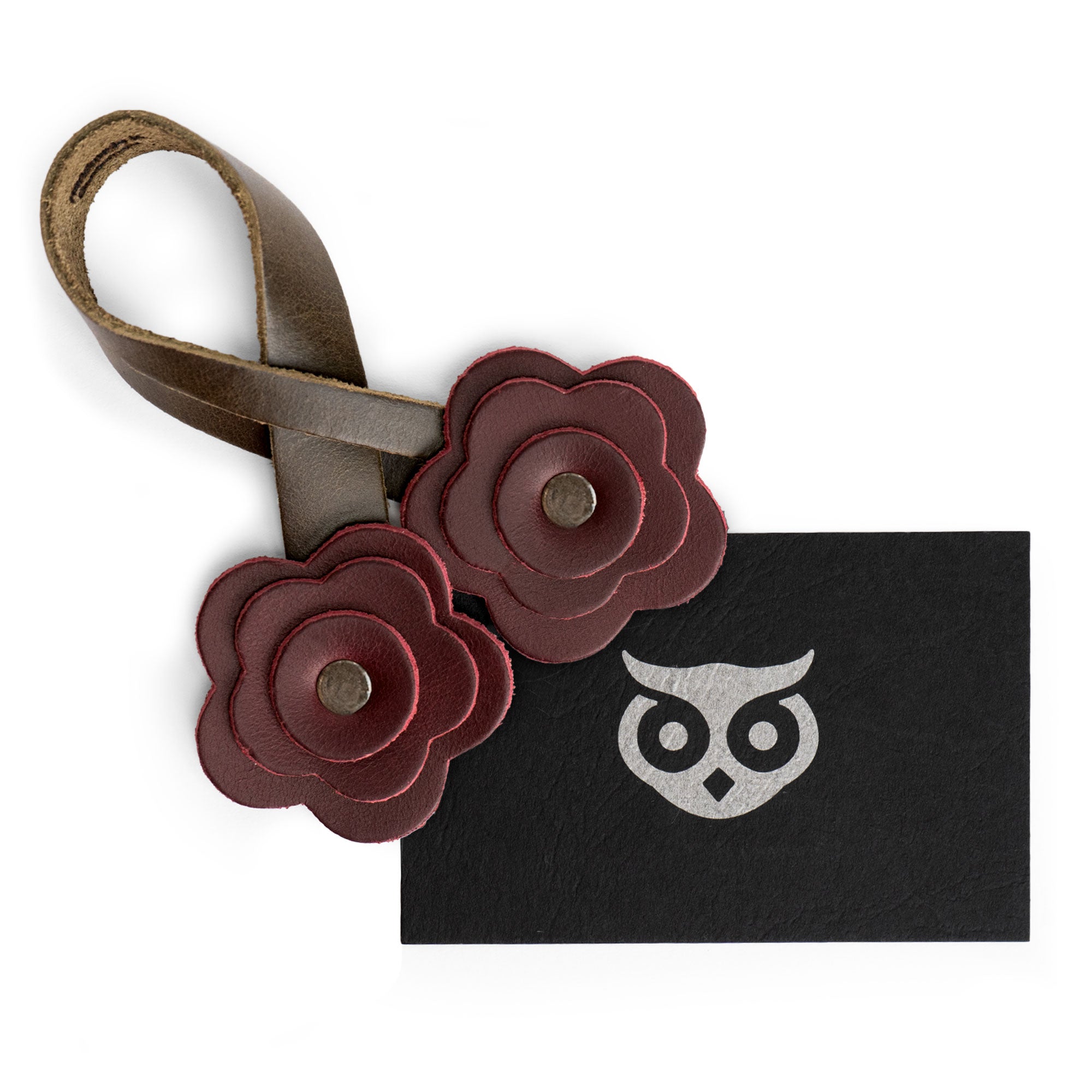 The Rose Bag Ornament by Hide & Drink displayed alongside a card, emphasizing its quality craftsmanship in Full Grain Leather, ideal as a flower-shaped accessory charm for bags and totes.