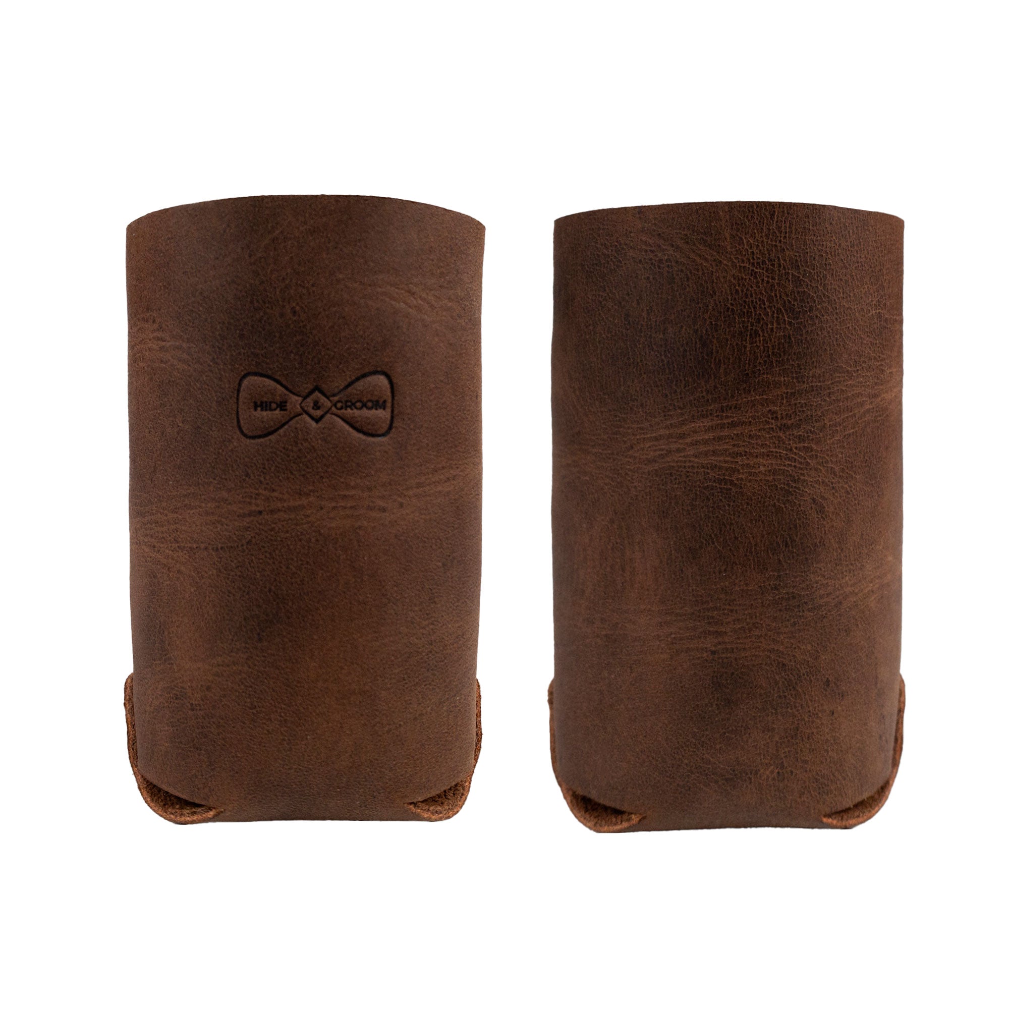Side view of the Hide & Groom Beer Can Sleeve (Set of 2) showcasing their rustic leather texture. These handcrafted sleeves serve as the best man accessories ideal for weddings. Made from full grain leather, they are hand cut and sewn, reflecting artisan craftsmanship from La Antigua Guatemala & Oaxaca Mexico.