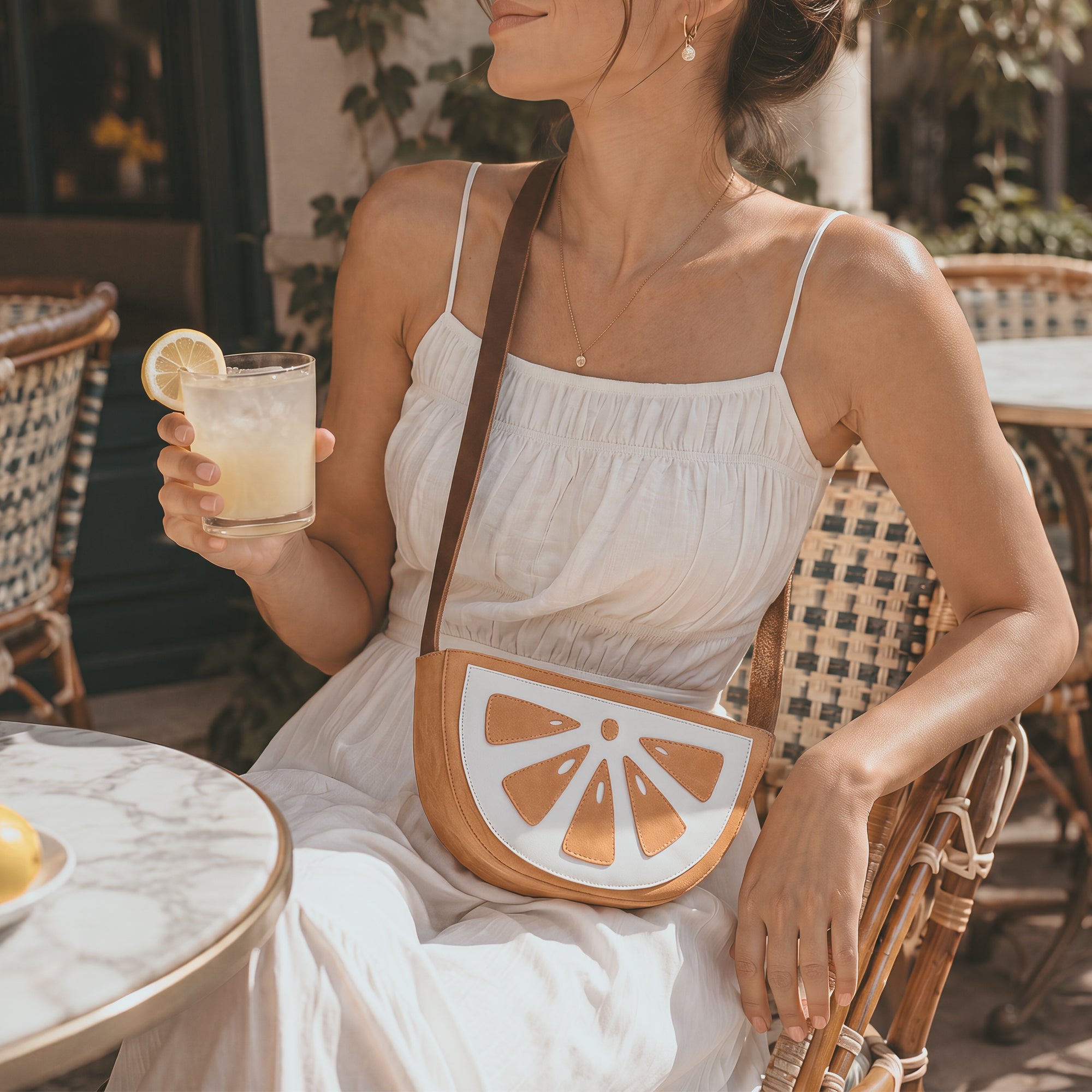 Model carrying the Lemon-Shaped Shoulder Bag by Tudi Frudi, highlighting its fashionable design while worn. This Lemon-Shaped Shoulder Bag with Adjustable Strap serves as a perfect Messenger Bag or Vintage Purse. Crafted from Full Grain Leather, it embodies Small Batch Production, and artisanal quality with hand cut and hand sewn details by artisans in La Antigua Guatemala & Oaxaca Mexico.