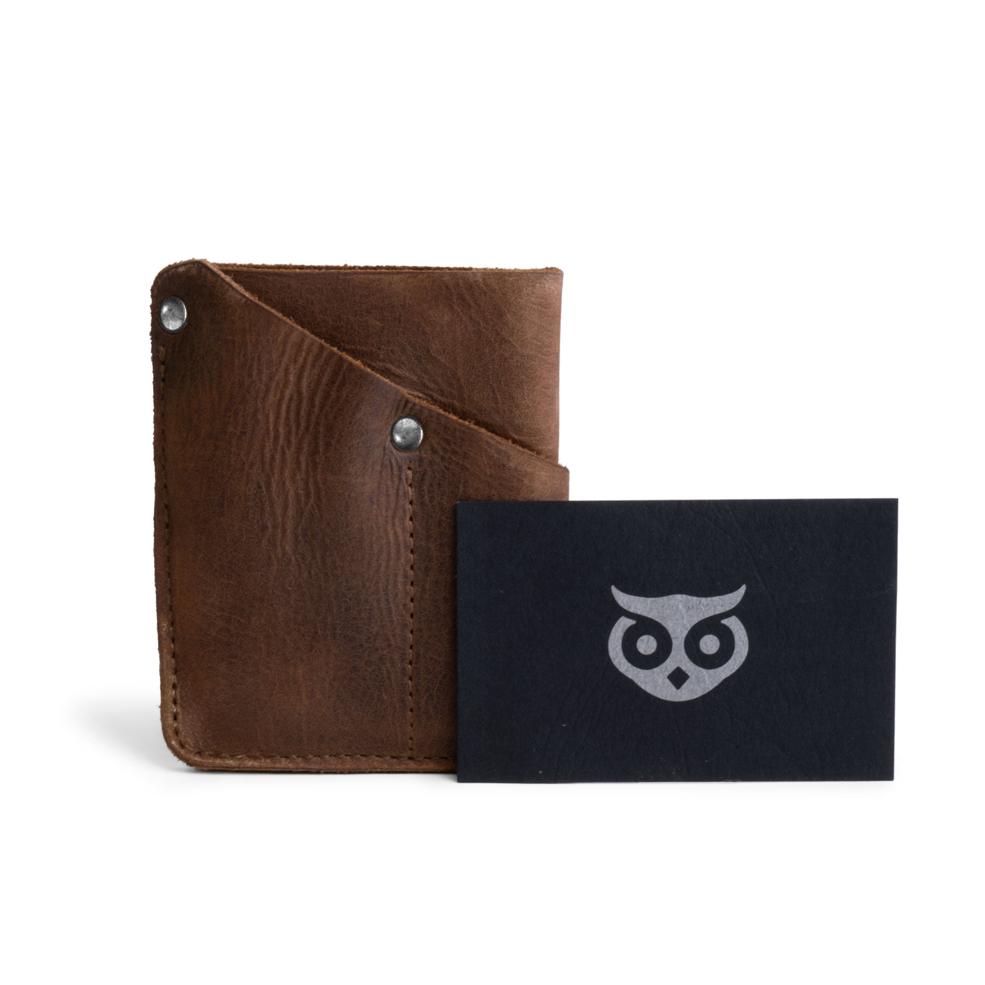 EDC Pocket Wallet by Hide & Drink displayed alongside a branded card, emphasizing its stylish design and full grain leather material. This handcrafted wallet serves as a multitool pouch, card holder, and money organizer for travel. Expertly made in small batches, it features hand cut, hand sewn, and fire branded details from La Antigua Guatemala & Oaxaca Mexico.