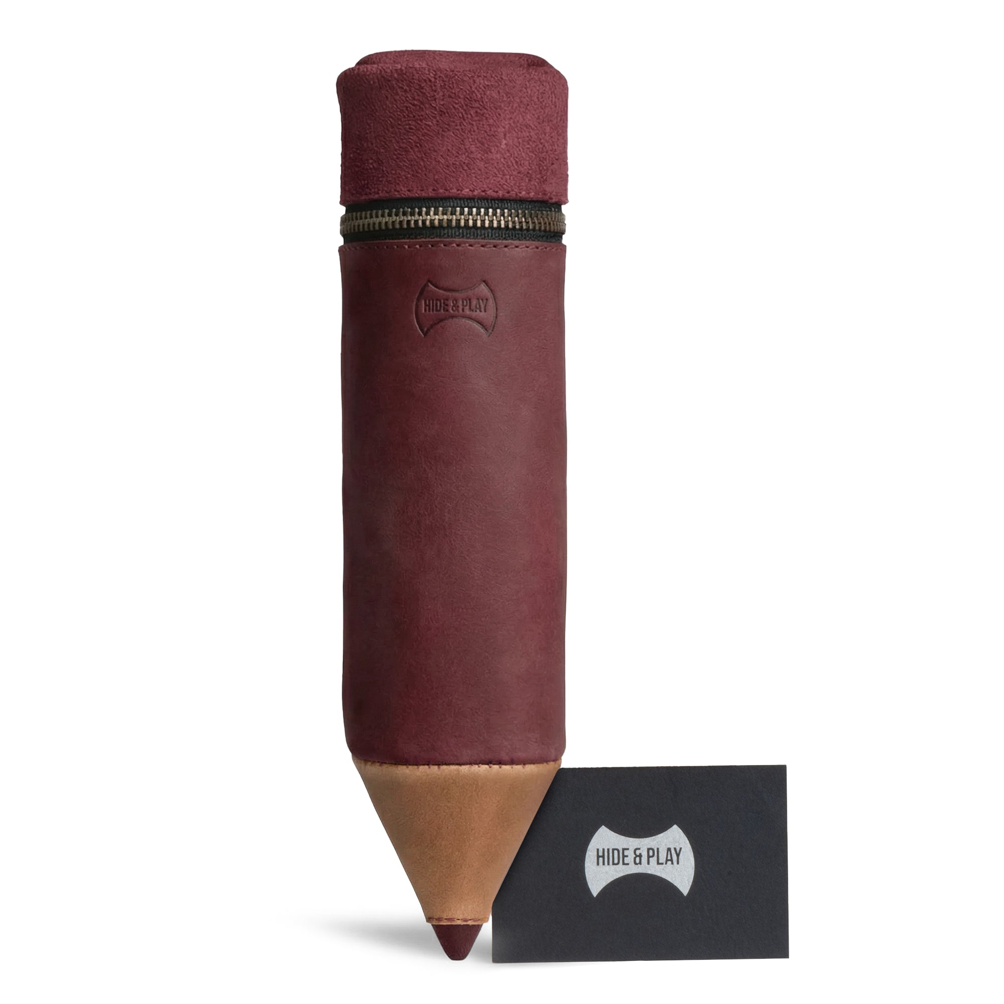 The Pencil-Shaped Case from Hide & Play alongside its branded card, demonstrating its unique design and premium quality. This artisan, zippered bag, perfect for pens, pencils, and markers, showcases hand cut and hand sewn features in full grain leather. Handmade in La Antigua Guatemala, this case reflects small batch production.