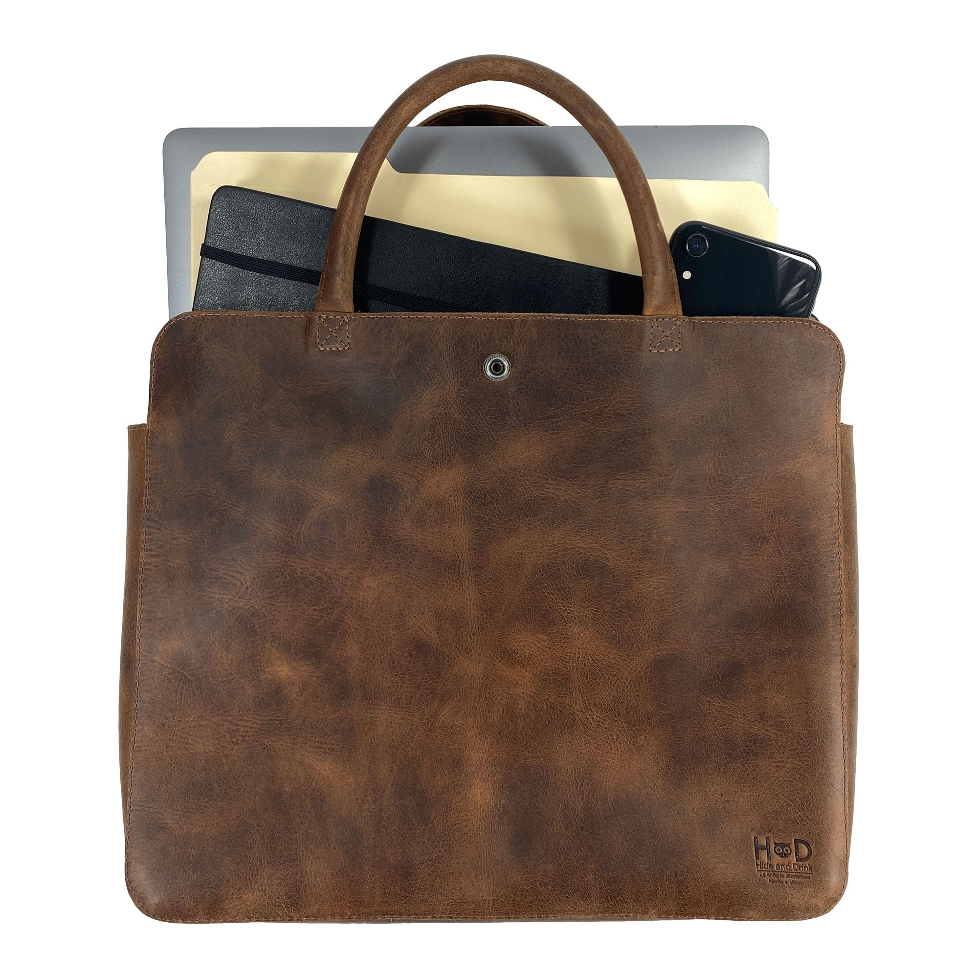 Vintage Portfolio with Snap for 13" MacBook Air by Hide & Drink, holding various items, emphasizing its spaciousness and durability made from Fine Full Grain Leather. This Artisan, Handmade in La Antigua Guatemala & Oaxaca Mexico, showcases hand-cut, hand-sewn craftsmanship and Small Batch Production quality.