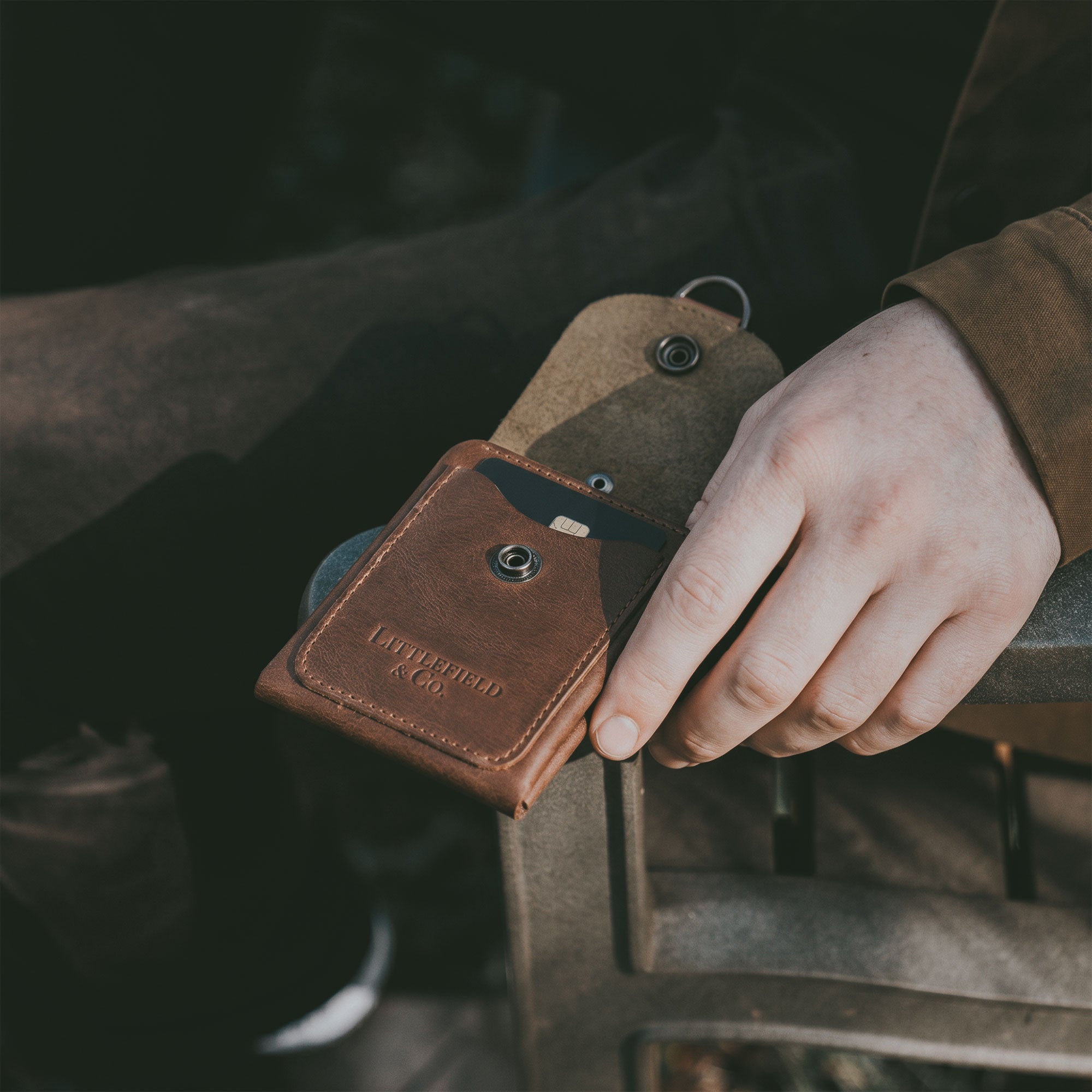 The Vintage Adventure Wallet by Littlefield Chicago is presented alongside a business card, emphasizing its practical yet stylish design. This full grain leather wallet acts as a compact men's bill organizer, ideal for travel accessories. Hand cut and hand sewn, it showcases the artisan production from La Antigua Guatemala & Oaxaca Mexico.