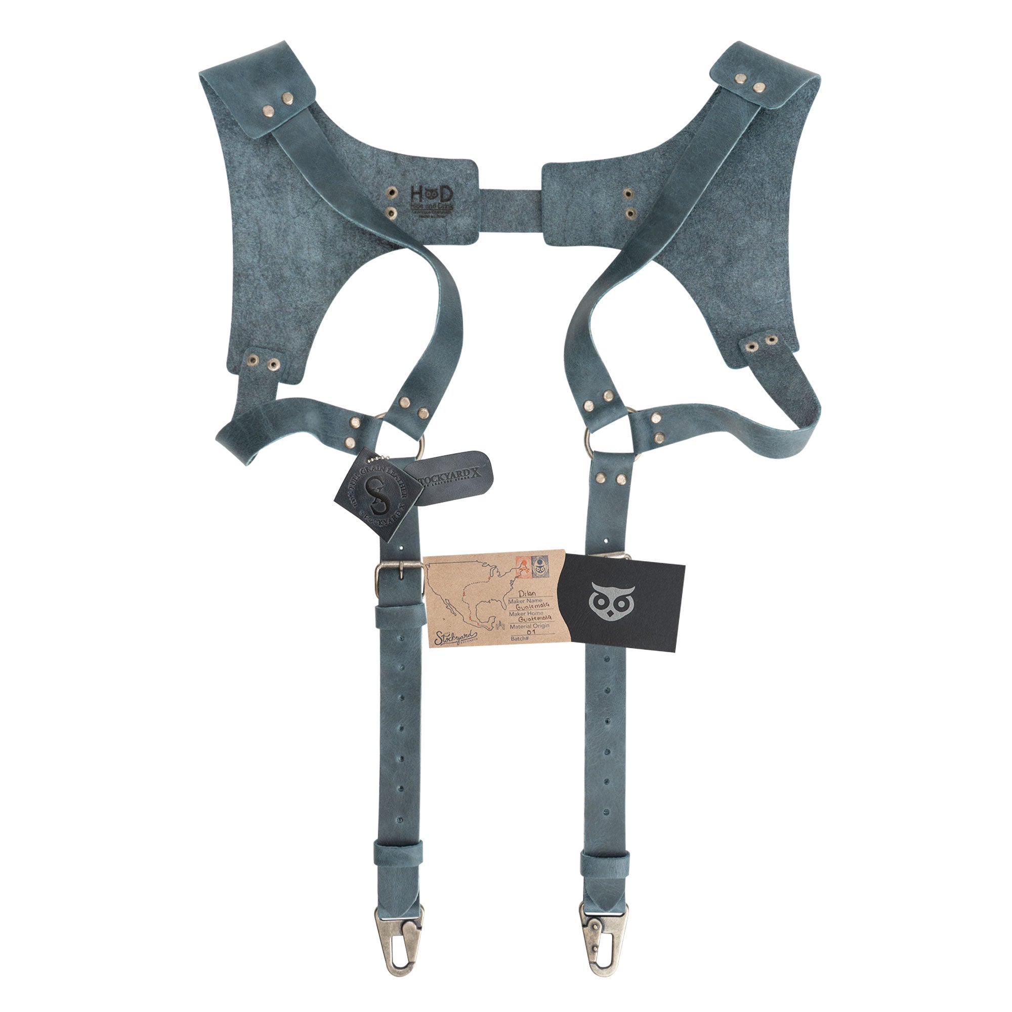 Dusty blue Renaissance Suspenders by Hide & Drink displayed with branding tag, focusing on quality. These back support harness for men are stylish for best men, showcasing artisan production.
