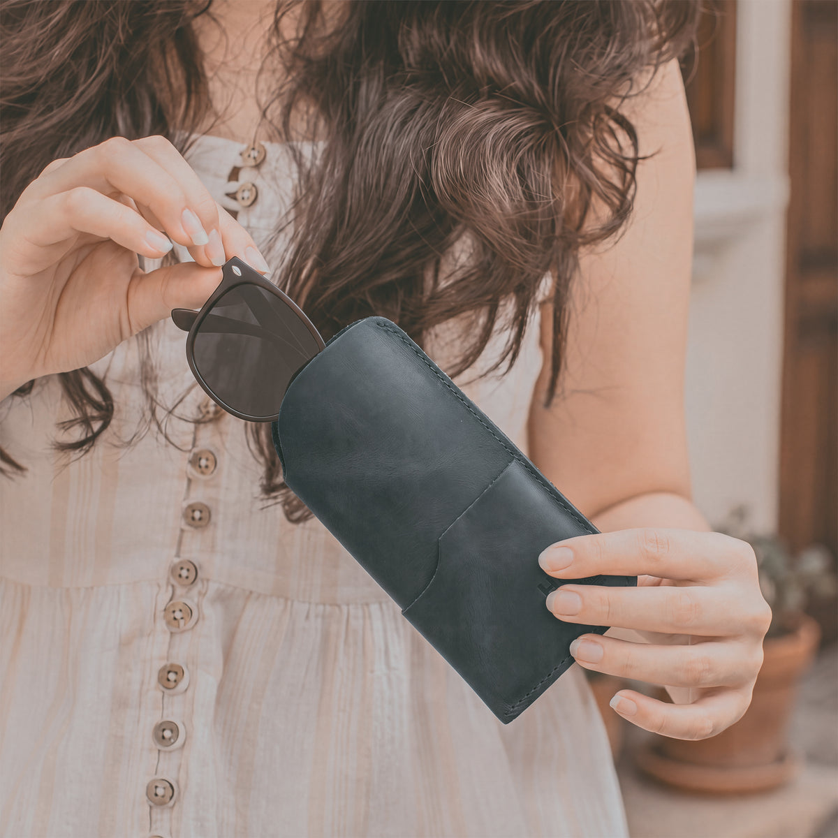 The Hide & Drink Sunglass Case & Wallet depicted in its practical use. This Rustic Sunglasses Case & Wallet, made from premium Full Grain Leather, serves as an essential eyeglasses sleeve for travel, expertly crafted in La Antigua Guatemala & Oaxaca Mexico.