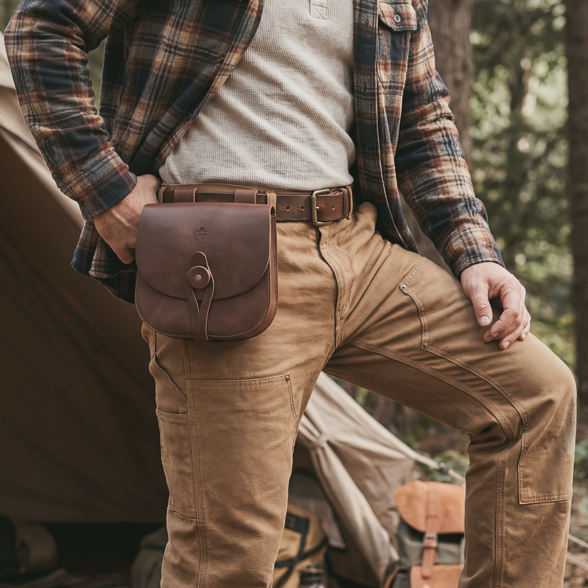 The Forester, Waist Bag by Valhalla Gear is shown on a person wearing the bag, showcasing its stylish and functional design suited for camping. This Medieval Style Waist Bag for Outdoors acts as a Leather Tool Organizer Belt Pouch, featuring vintage loops for belts perfect for both men and women. Made from full grain leather, it exemplifies artisan craftsmanship with handmade quality from La Antigua Guatemala & Oaxaca Mexico.