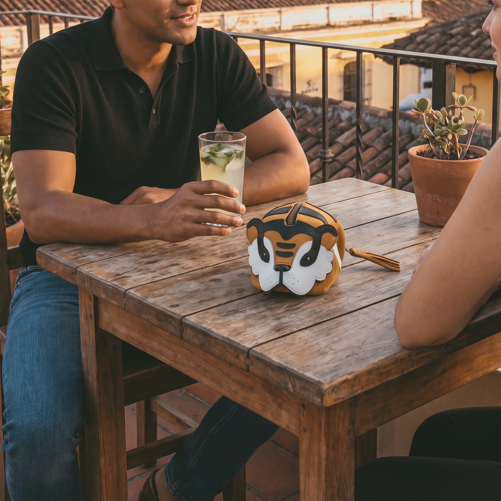 Casual scene with the Tiger Leather Pouch by Tudi Frudi, illustrating its charm as a Tiger-Shaped Pouch suitable for gatherings. This unique purse doubles as a Small Charger Cable Holder and is crafted from durable Full Grain Leather in small batch production.