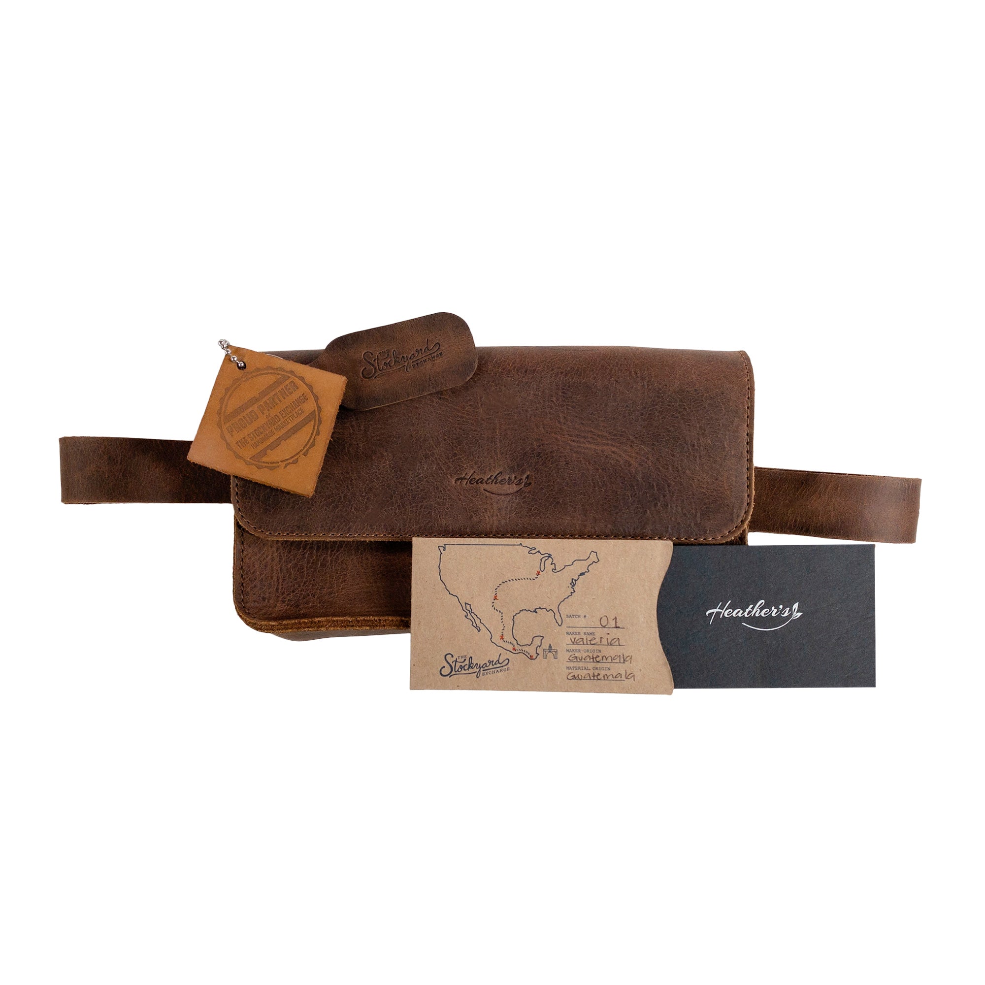 Presentation of Heather's Rectangular Fanny Pack, featuring tags and documentation that highlight its artisan origins. Made from full grain leather, this hip bag merges style with functionality. Handmade in La Antigua Guatemala & Oaxaca Mexico, it exemplifies small batch production and quality craftsmanship.