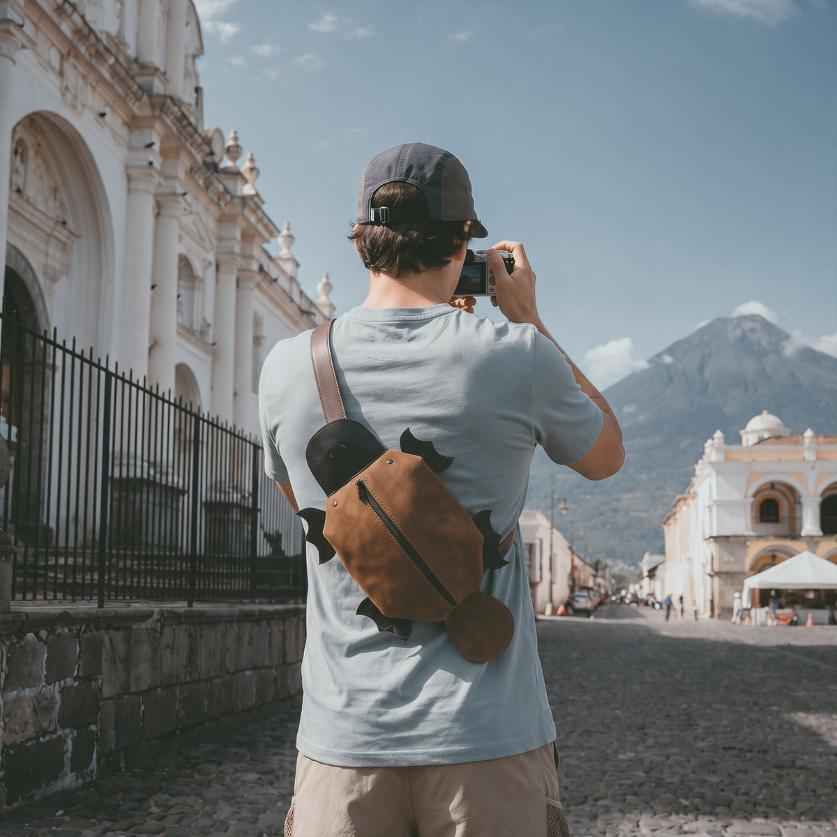 Traveler wearing the Tudi Frudi Platypurse Crossbody Bag as a comfortable Adjustable Shoulder Strap Messenger Bag while exploring Guatemala, featuring its Swayze Suede and Full Grain Leather body, Zippered Sling Bags styling, Shoulder Bag and Travel Backpack versatility, Purses for Men and Women appeal, Satchel design, StockyardX Small Batch Production, Hand Cut and Hand Sewn Artisan craftsmanship, Fire Branded detail, Handmade in La Antigua Guatemala & Oaxaca Mexico.