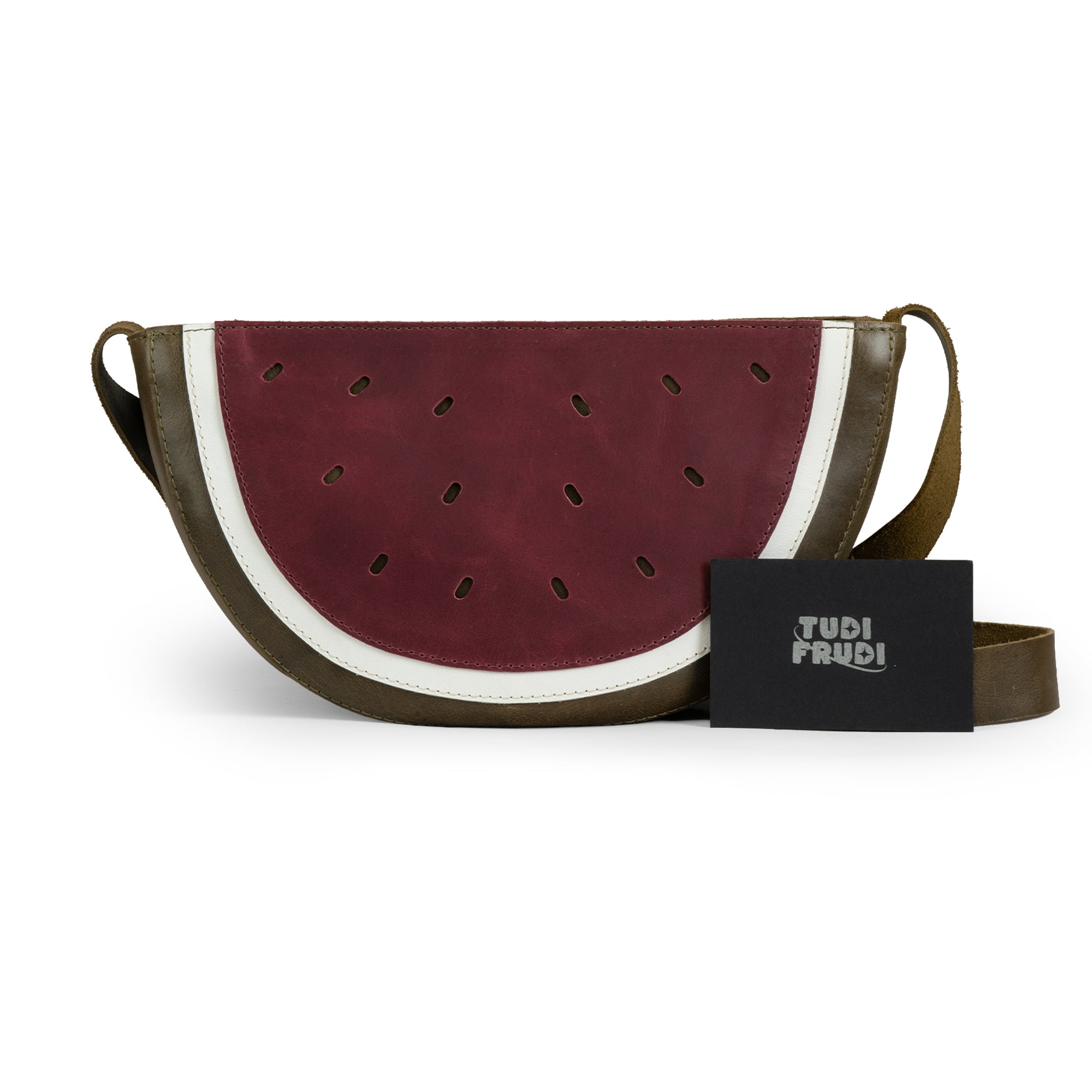 Detailed view of the Watermelon-Shaped Shoulder Bag by Tudi Frudi with tags showing its artisan origin. This eye-catching Crossbody Bag and Messenger Bag is made from high-quality Full Grain Leather and showcases the brand's dedication to small batch production, hand cut, hand sewn, and fire branded craftsmanship. Handmade in La Antigua Guatemala & Oaxaca Mexico.