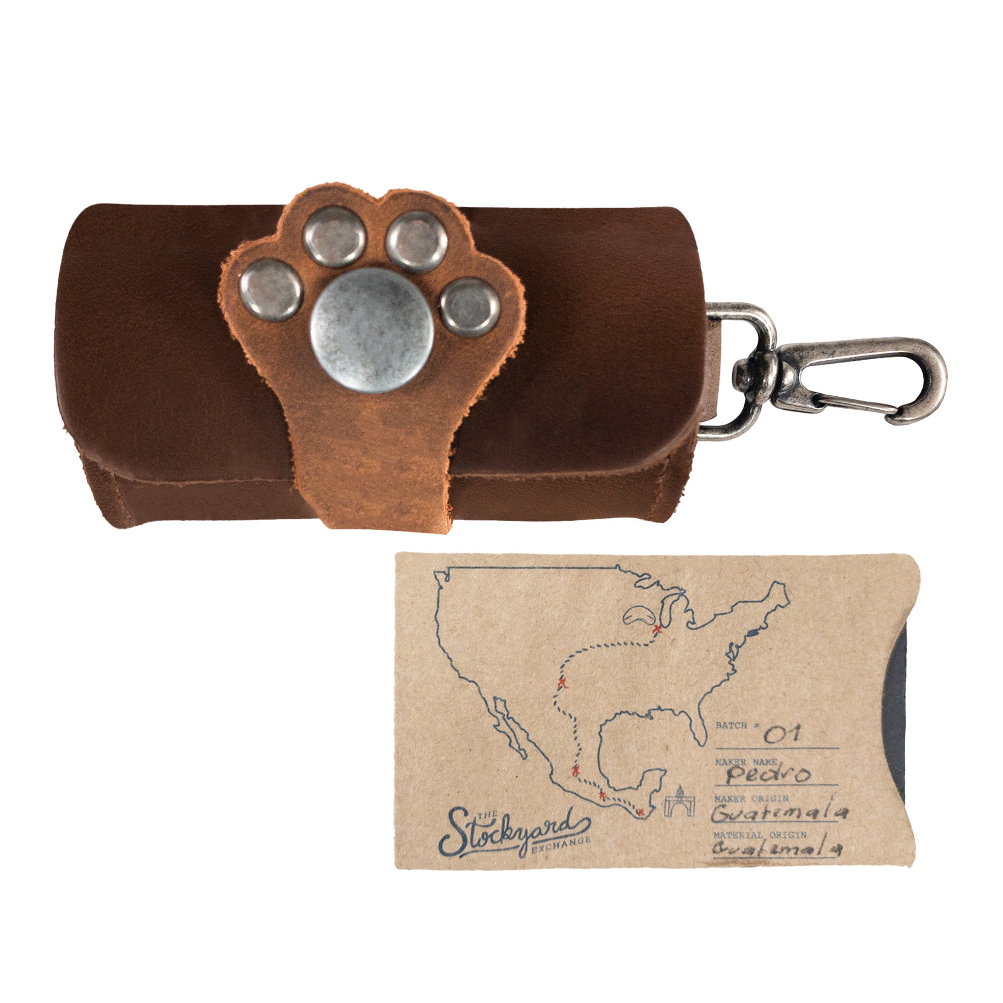 Taco Dog Paw Poop Bag Pouch next to a unique artisan tag, highlighting the small batch production from La Antigua Guatemala. This stylish full grain leather carrier clips onto leashes and offers easy disposal during dog walks, emphasizing quality and practicality.