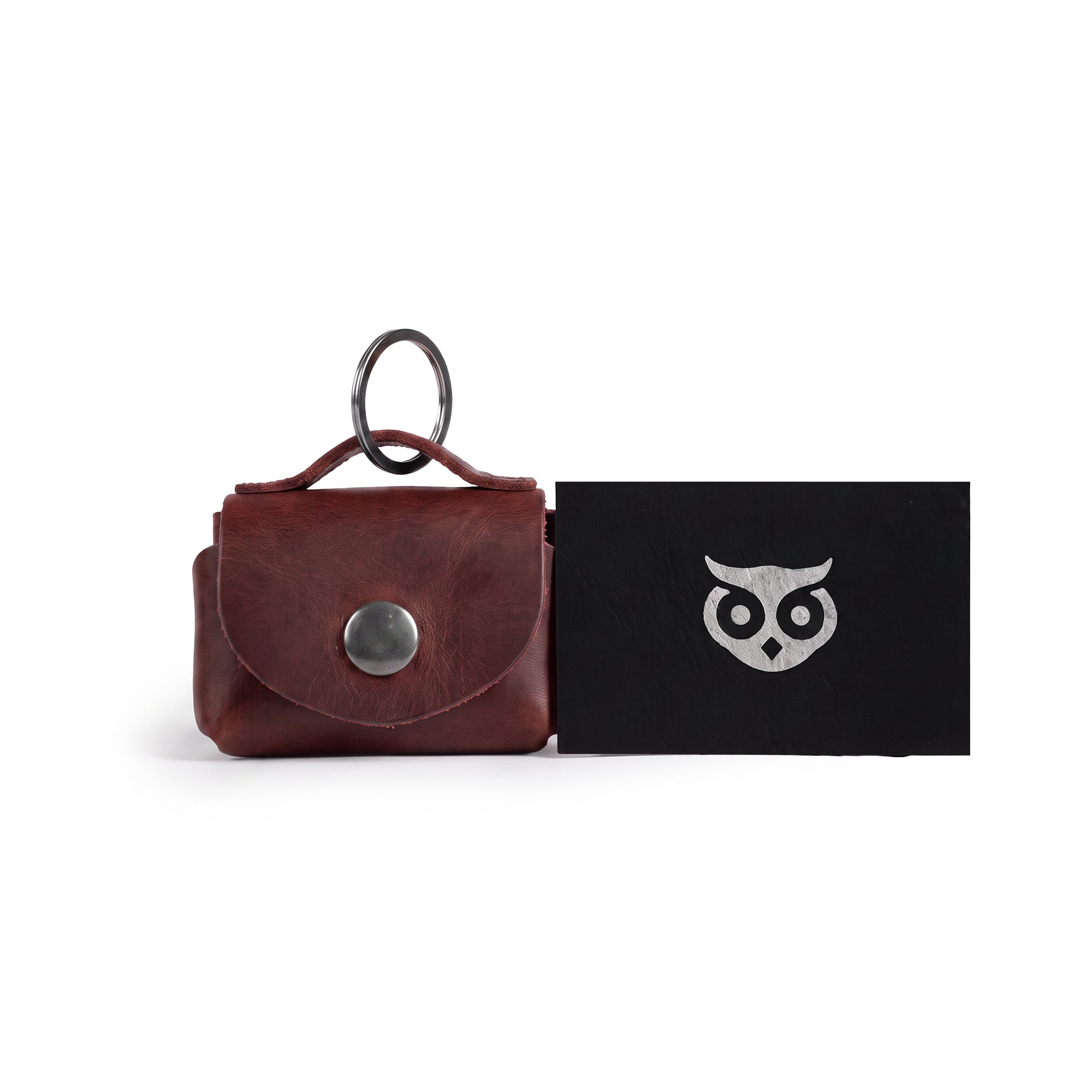 The Tiny Handbag Keychain by Hide & Drink alongside other artisanal items, showcasing its rustic charm and Full Grain Leather finish. Hand cut and hand sewn, this item embodies the spirit of small batch production from La Antigua Guatemala.