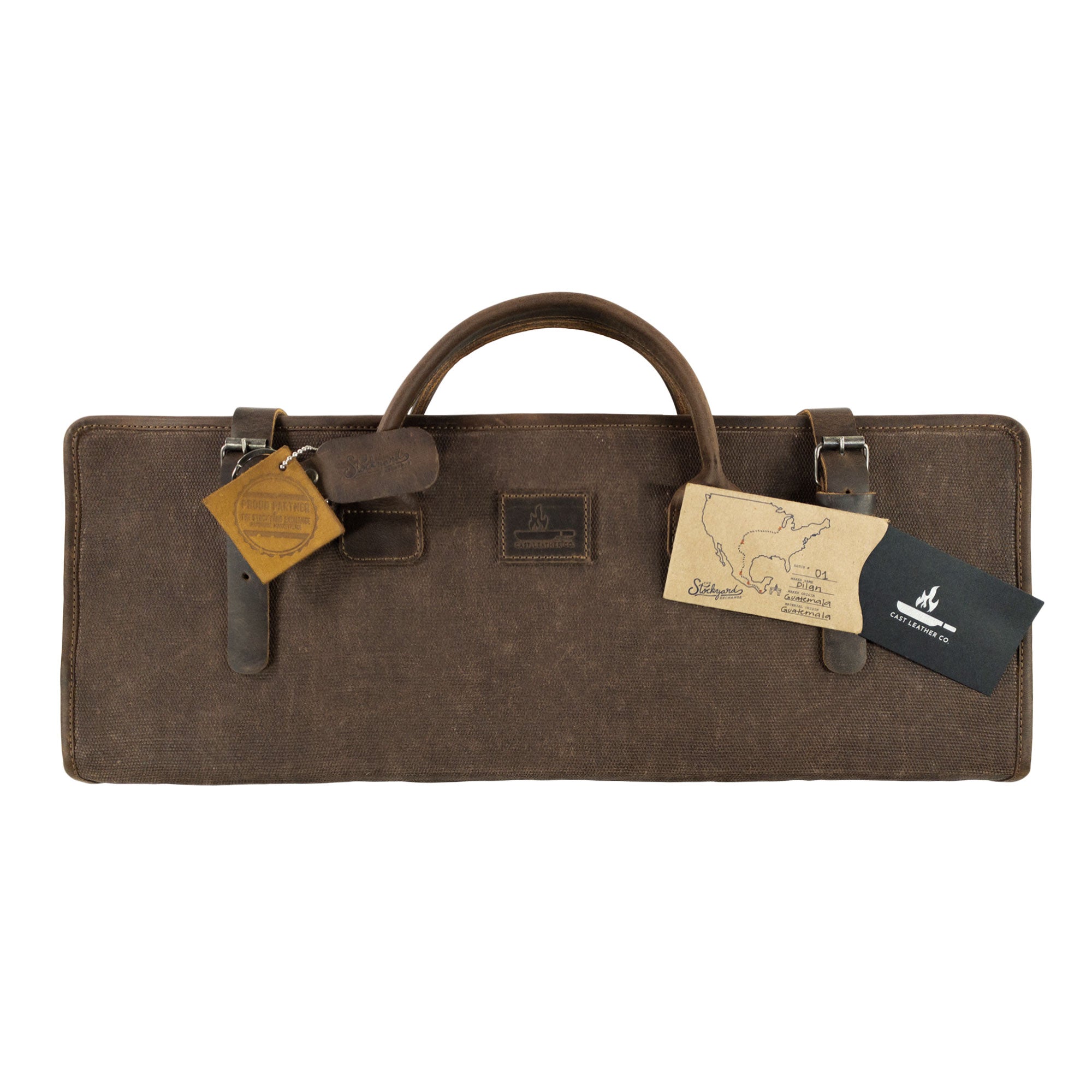 Detailed view of Cast Leather Co. Grill Tool Holder (Tools NOT included), featuring tags highlighting its artisan origins. This carry bag for BBQ grilling accessories, made from full grain leather and waxed canvas, is a perfect camping set storage solution. Each item is hand cut and sewn, signifying small batch production from artisans in La Antigua Guatemala and Oaxaca Mexico.