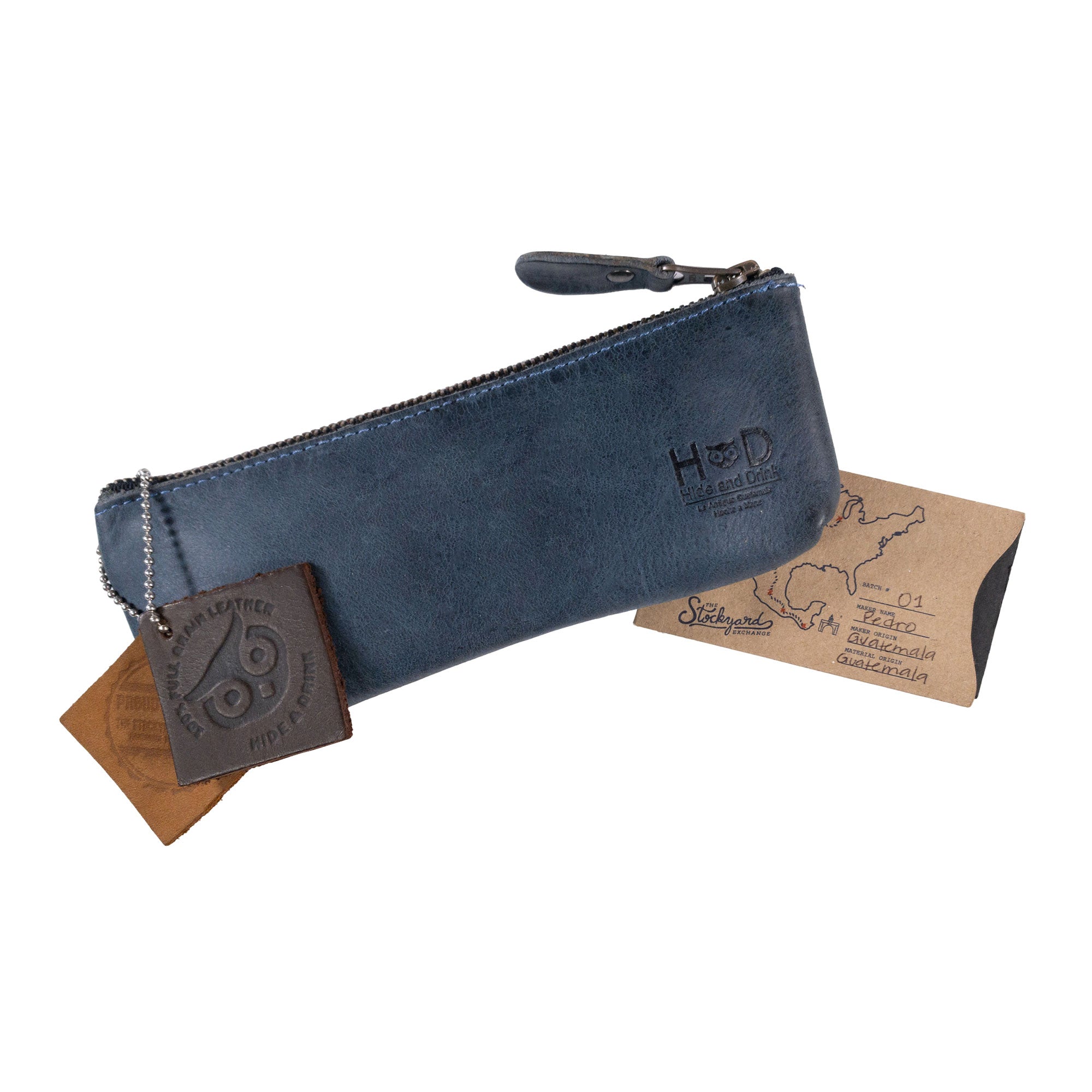 Hide & Drink Pencil Pouch with tags showcasing branding and handcrafted details, highlighting its quality and style as a rectangular pencil case. Perfect for storing pens and markers, it represents a classic design loved by both men and women, crafted from full grain leather and handmade in La Antigua Guatemala & Oaxaca Mexico.