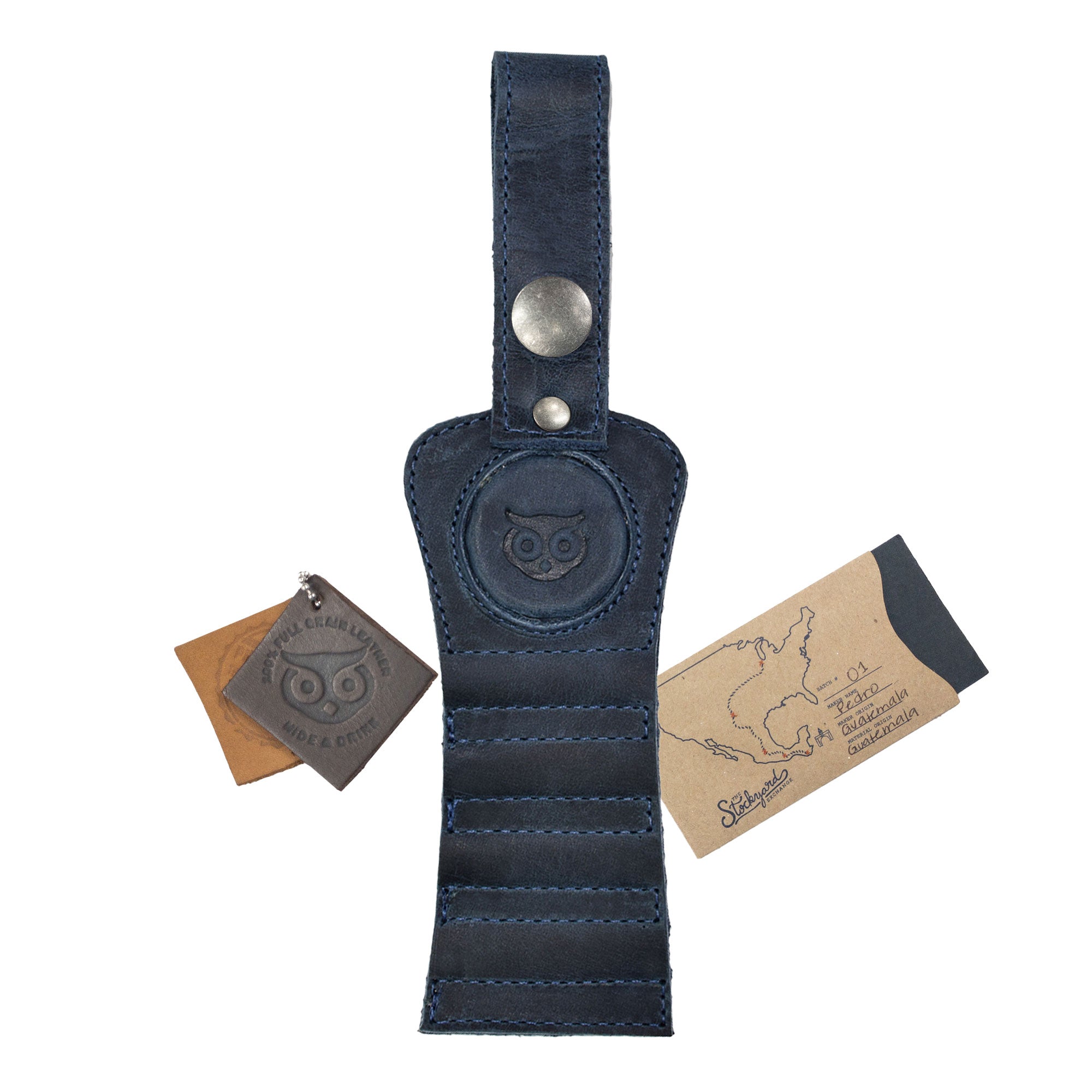 Hide & Drink Golf Tee Holder in navy leather paired with branded tags, showcasing its quality. This unique golf accessory is perfect for carrying tees conveniently, handmade in La Antigua Guatemala.