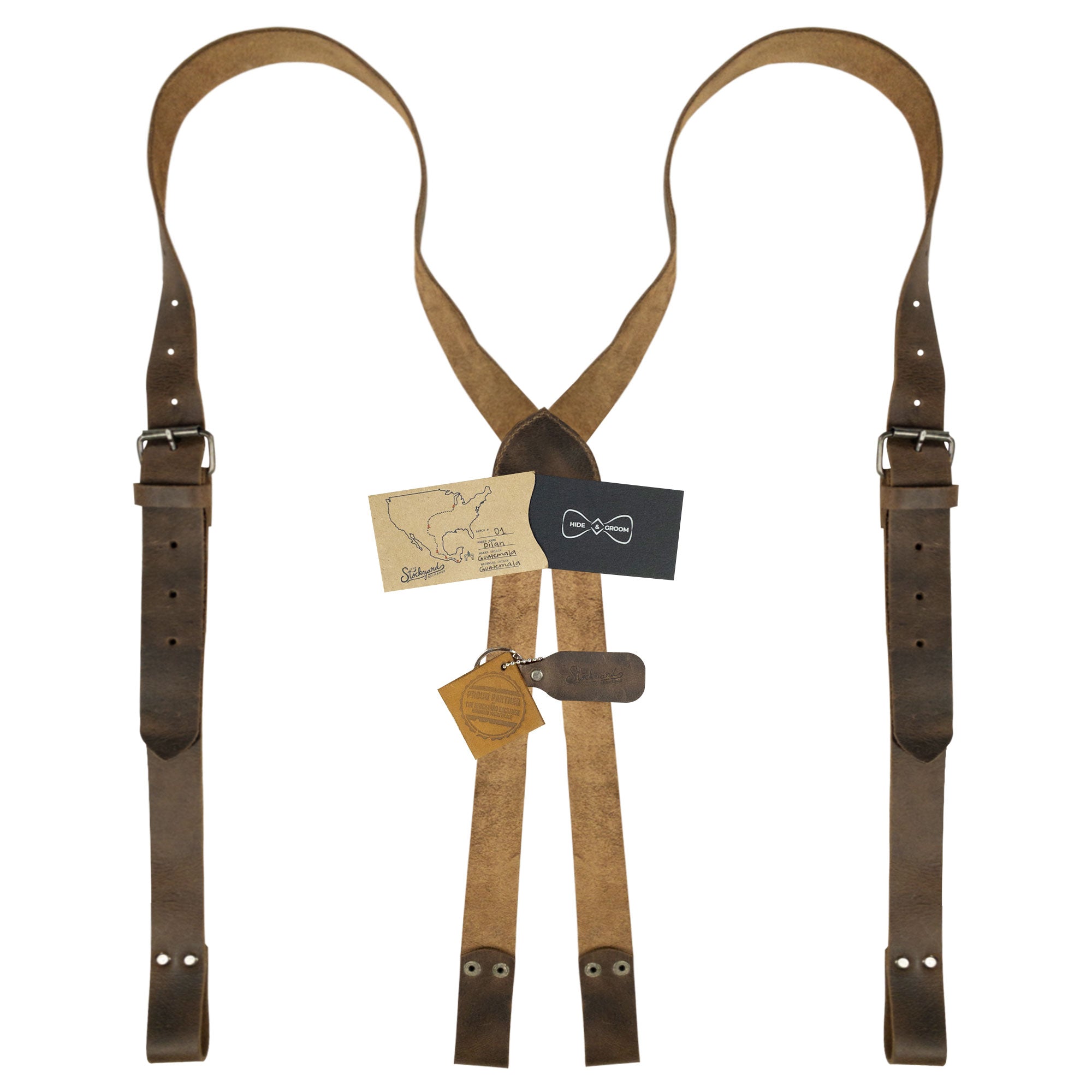 Hide & Groom's X Back Formal Suspenders with Belt Loops displayed with product tags, showcasing artisan craftsmanship and quality materials. Perfect for formal wear and groomsmen, these handmade suspenders feature adjustable straps made of full grain leather.