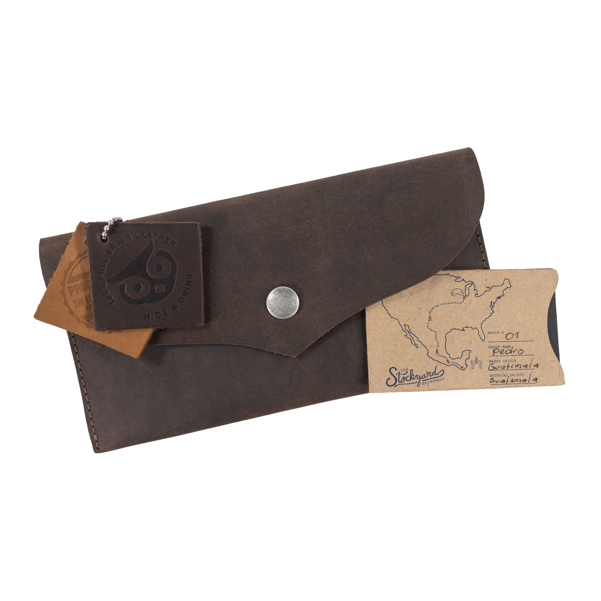 Packaging details of the Cash Pouch with Rivets by Hide & Drink, featuring its unique branding and tags. This handmade wallet emphasizes the artisan craftsmanship in full grain leather. Cash Pouch, Wallet, Money Organizer, Coin Case, Bill Holder, ID Case, StockyardX, Handmade, Full Grain Leather, Small Batch Production, Hand Cut, Hand Sewn, Fire Branded, Artisan, Handmade in La Antigua Guatemala & Oaxaca Mexico.