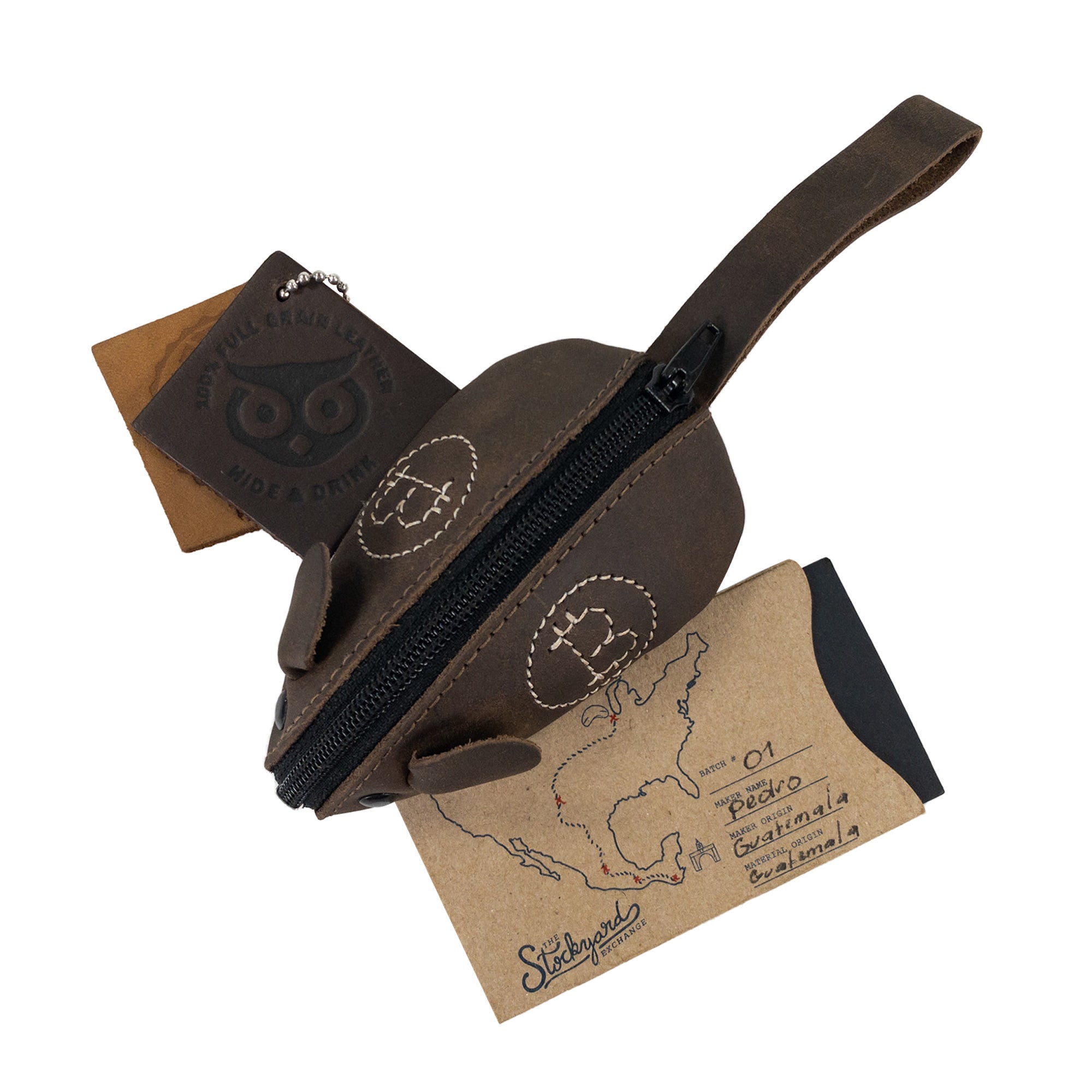 The Mouse Coin Pouch by Hide & Drink shown filled with cards and a few coins portrays its versatility as a charming travel accessory. Made from full grain leather, this mouse-shaped pouch is a unique pocket case for coins, meticulously hand cut and hand sewn by artisans in La Antigua Guatemala and Oaxaca, Mexico, upholding the spirit of small batch production.