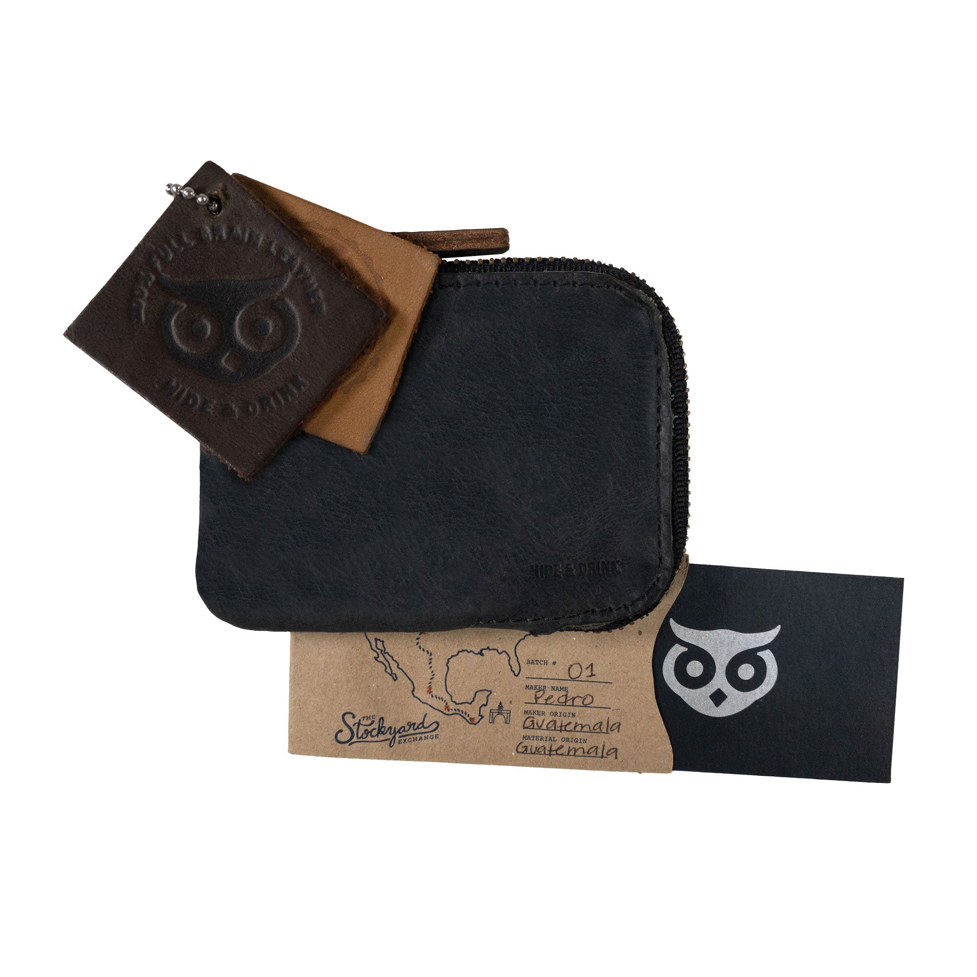 A black Hide & Drink Card Pocket Wallet presented with tags highlighting its features and authenticity. This zippered card wallet for men and women is perfect as a coin pouch and money holder, crafted from full grain leather in La Antigua Guatemala, showcasing small batch artisan production.