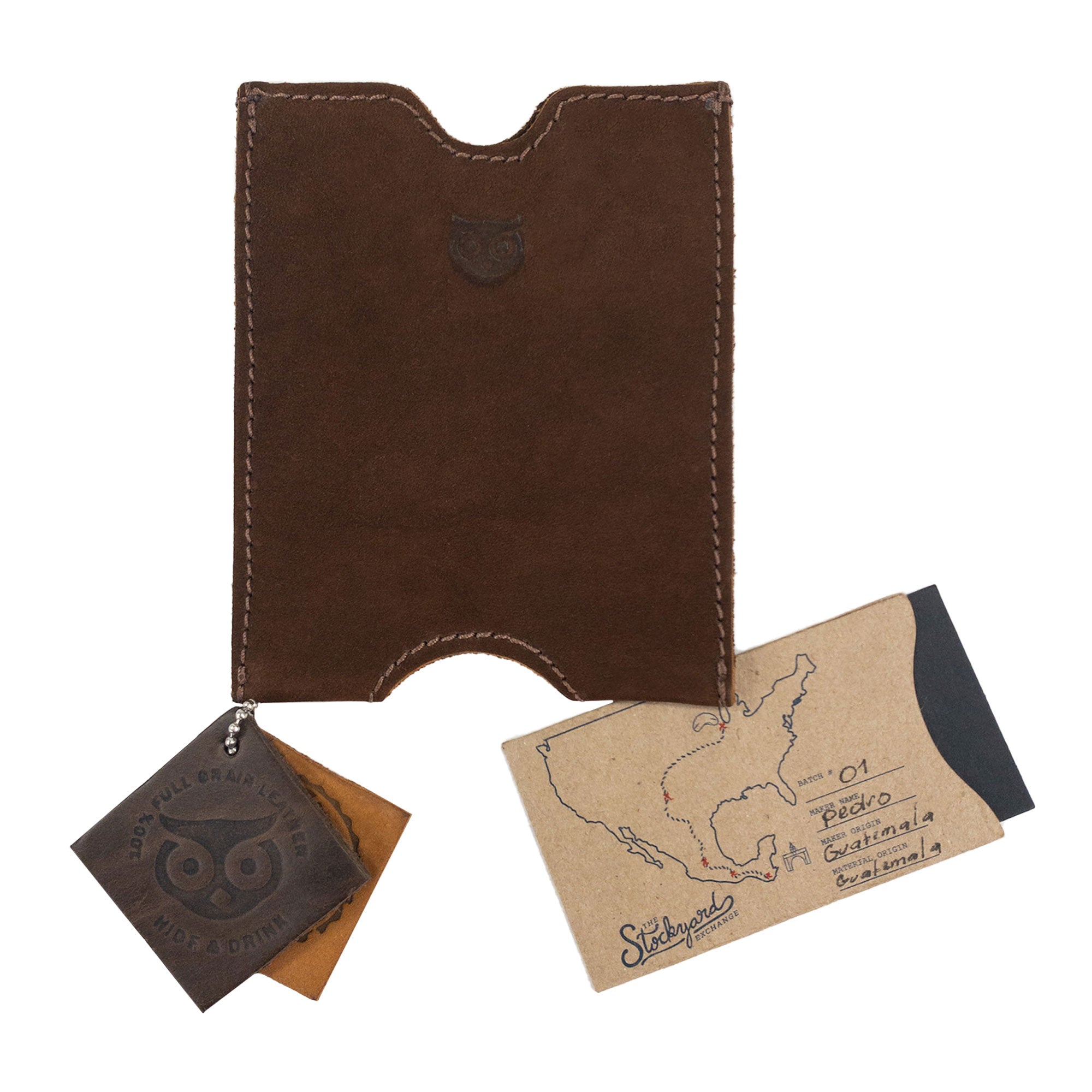 Hide & Drink's Passport Sleeve displayed with artisan tags, emphasizing its handmade nature. This Full Grain Leather Travel Passport Pocket Sleeve is fire branded and crafted in La Antigua Guatemala.