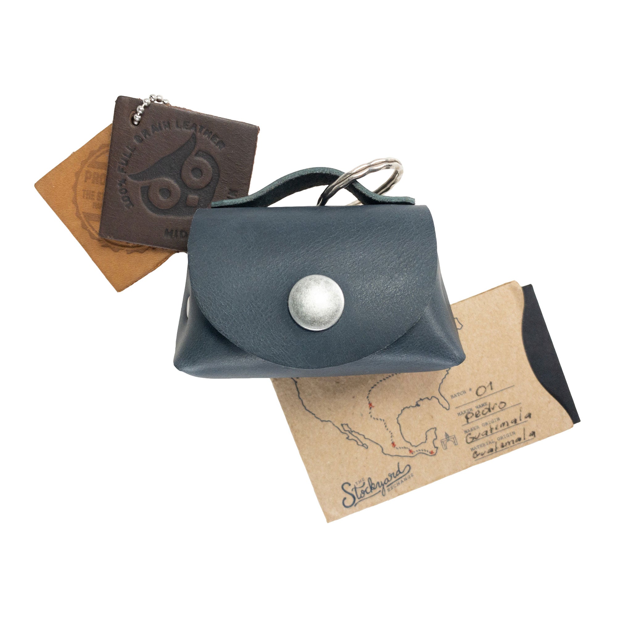 Top view of the Tiny Handbag Keychain by Hide & Drink combined with other leather goods, showcasing its handmade quality. Crafted from Full Grain Leather in small batches, this artisan piece from StockyardX fits perfectly in any collection of unique accessories.