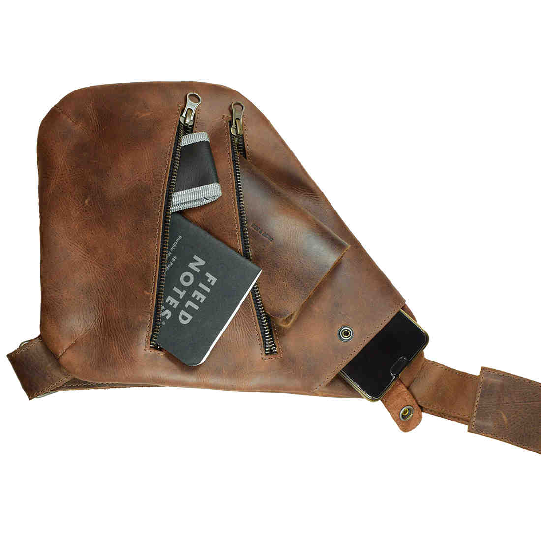 The interior of the Kidney Shoulder Bag by Hide & Drink, showcasing its organization capabilities as an Everyday Crossbody Bag. Made from Full Grain Leather, this handmade bag reflects artisan craftsmanship with hand cut and hand sewn details, proudly produced in La Antigua Guatemala & Oaxaca Mexico.