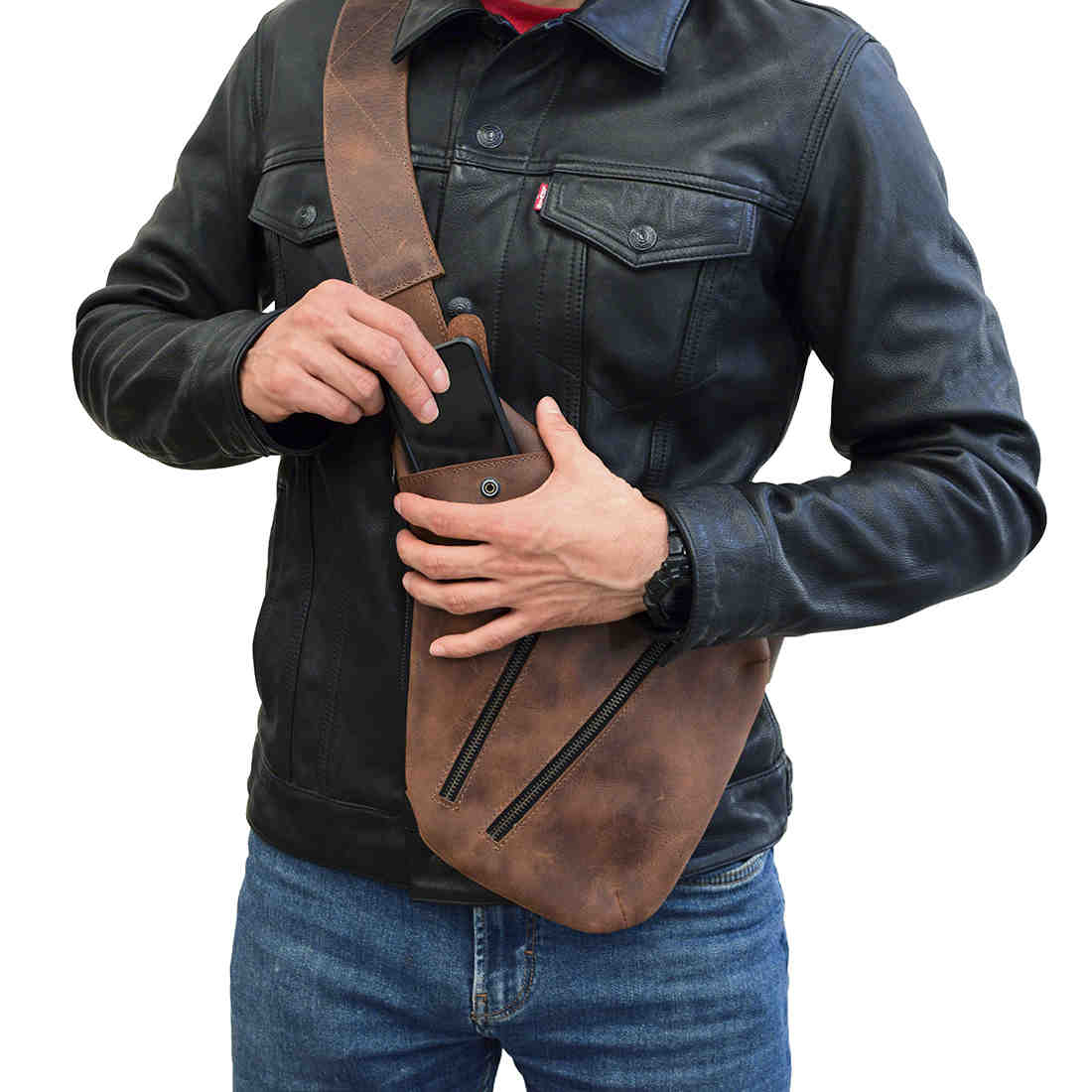 The Kidney Shoulder Bag by Hide & Drink being used to store a phone, emphasizing its practicality as an Everyday Crossbody Bag. Handcrafted from Full Grain Leather, this artisan piece features a durable and stylish appeal, made with meticulous attention in La Antigua Guatemala & Oaxaca Mexico.