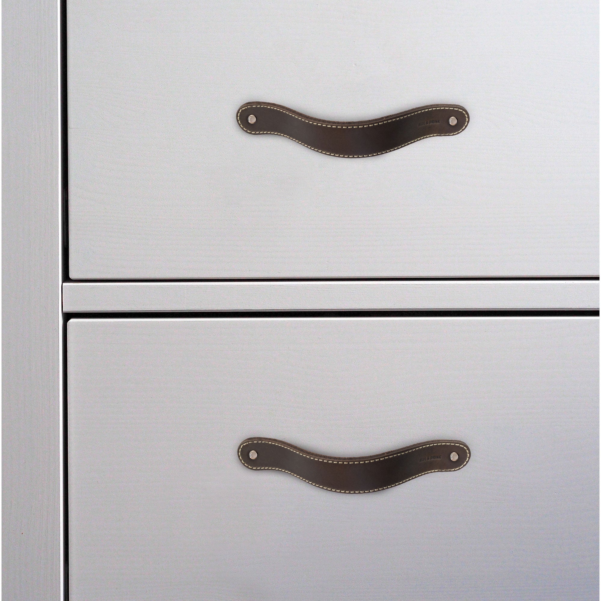 Hide & Drink Drawer Handles (4pk) showcasing a single leather handle on a plain backdrop, highlighting its quality and design. An artisan-made piece, perfect for adding a touch of style to your furniture.
