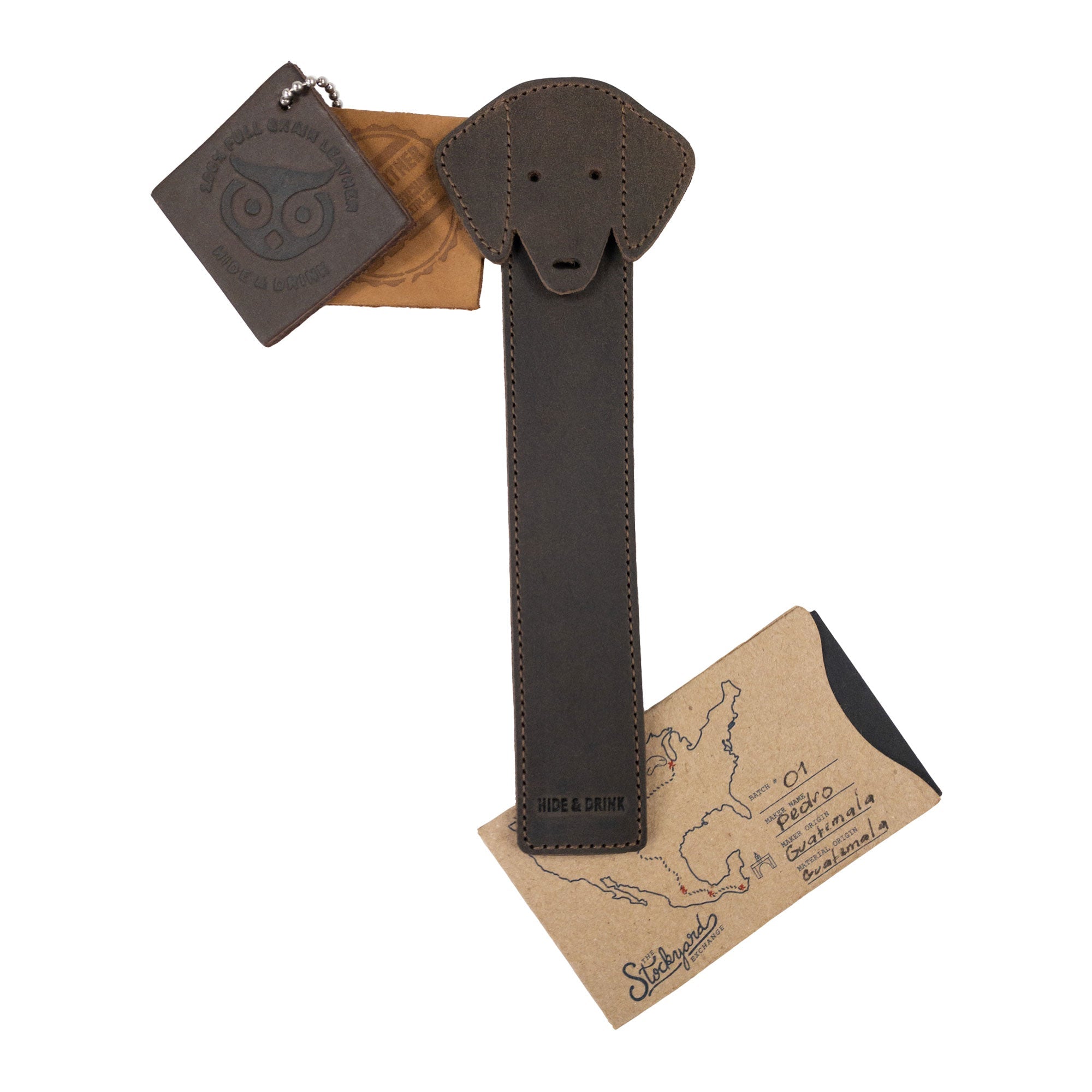 Hide & Drink's Dog Bookmark presented with its packaging, emphasizing its Full Grain Leather material and artisan quality. This handmade bookmark reflects small batch production and fire branded elements, created in La Antigua Guatemala & Oaxaca Mexico.