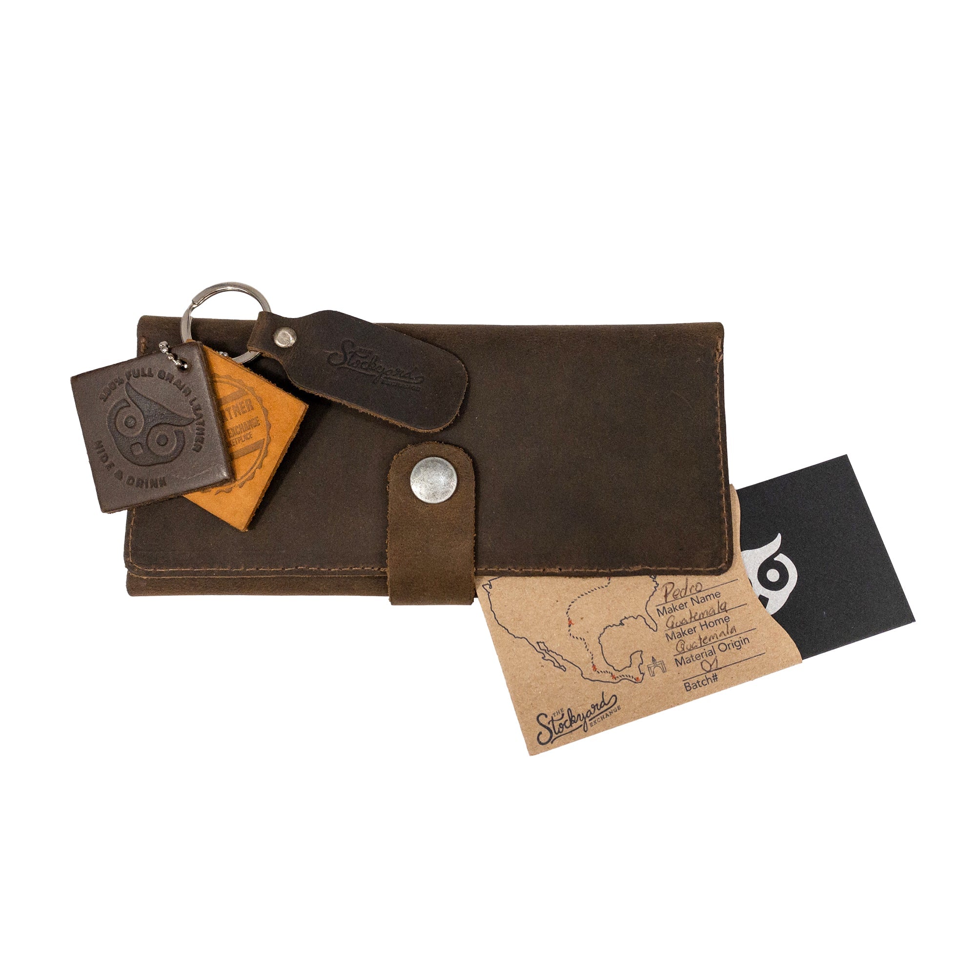 Image of the Hide & Drink Folio Wallet With Pouch alongside its product tag, highlighting its artisan production and unique features. Made from full grain leather, this wallet is perfect for organizing cards and cash, emphasizing small batch craftsmanship and handmade quality.