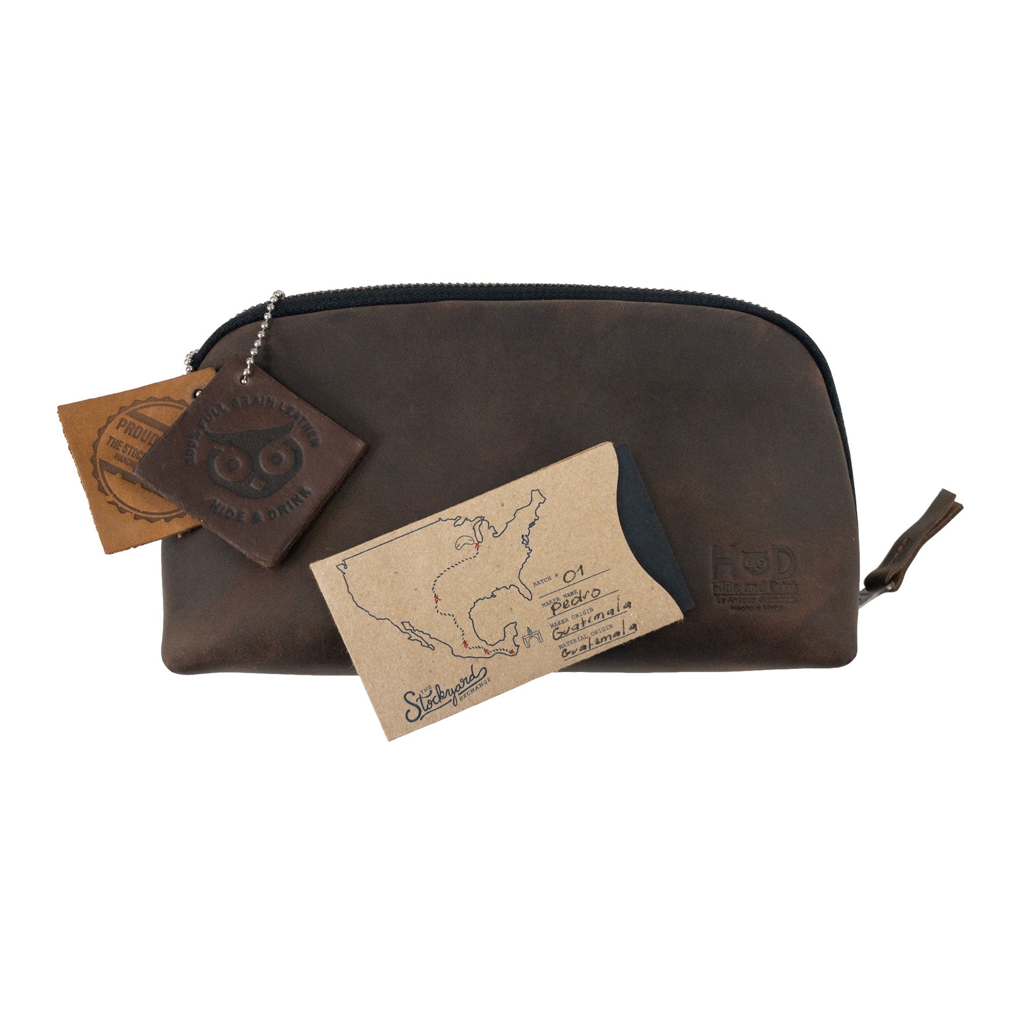 Hide & Drink's Small Tech Organizer displayed with its tags, showcasing its rustic charm and artisanal quality. This small tech bag is perfect for organizing your chargers and cables, crafted from high-quality full grain leather in La Antigua Guatemala & Oaxaca Mexico.