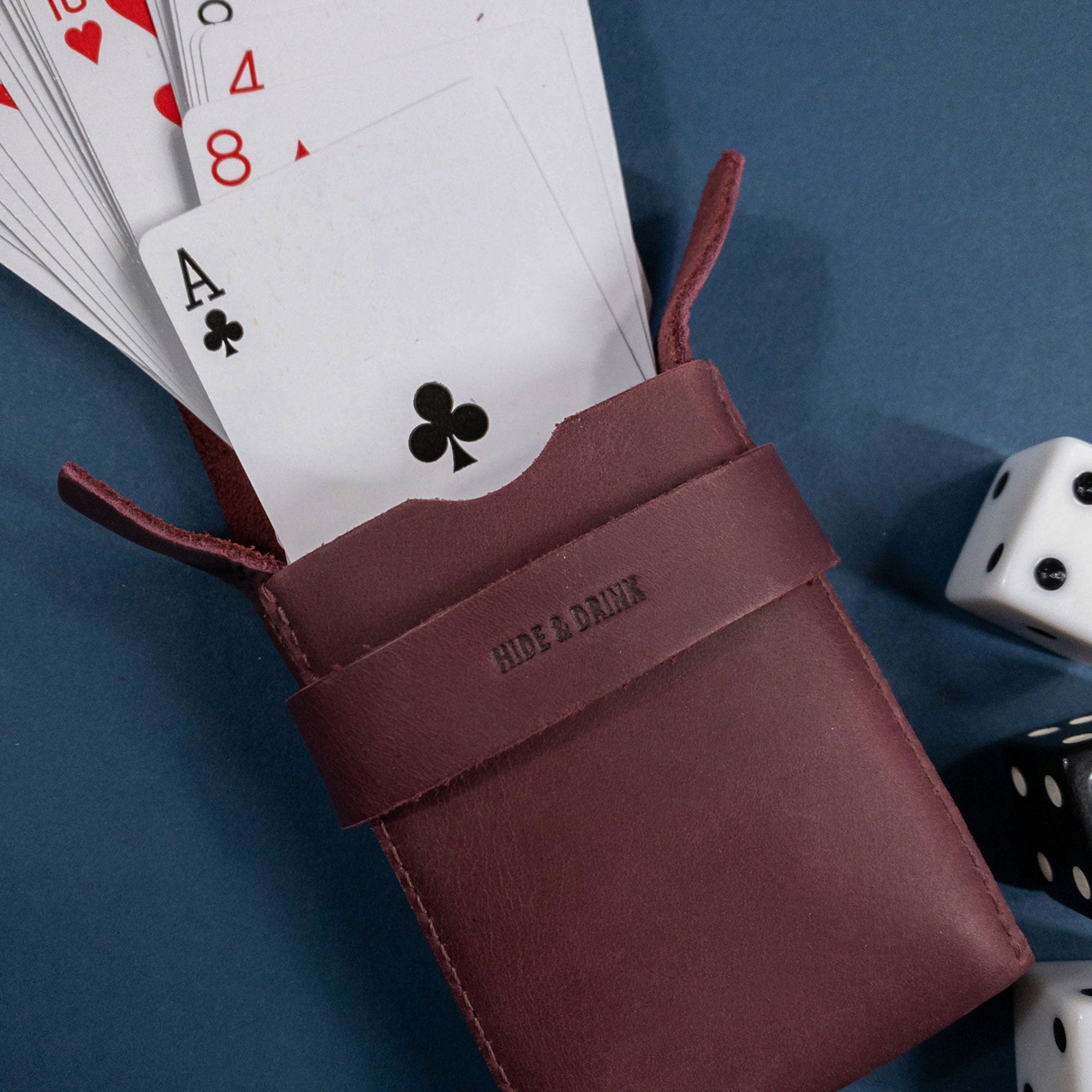 Hide & Drink's Playing Card Case with a deck of cards ready to play. This travel accessory is perfect for securely storing your classic playing cards (not included), made from high-quality full grain leather. Handcrafted with care, it showcases StockyardX's artisan quality.