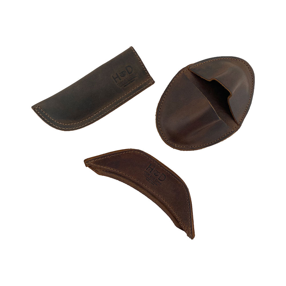 A stylish set of 3 Rustic Hot Handle Holders from Hide & Drink, showcasing the Panhandle, Side Kick, and Grip Mitt, perfect for assisting with cast iron skillets and pans. Made of Full Grain Leather through Small Batch Production, each piece is Hand Cut, Hand Sewn, and Fire Branded by artisans in La Antigua Guatemala & Oaxaca Mexico.