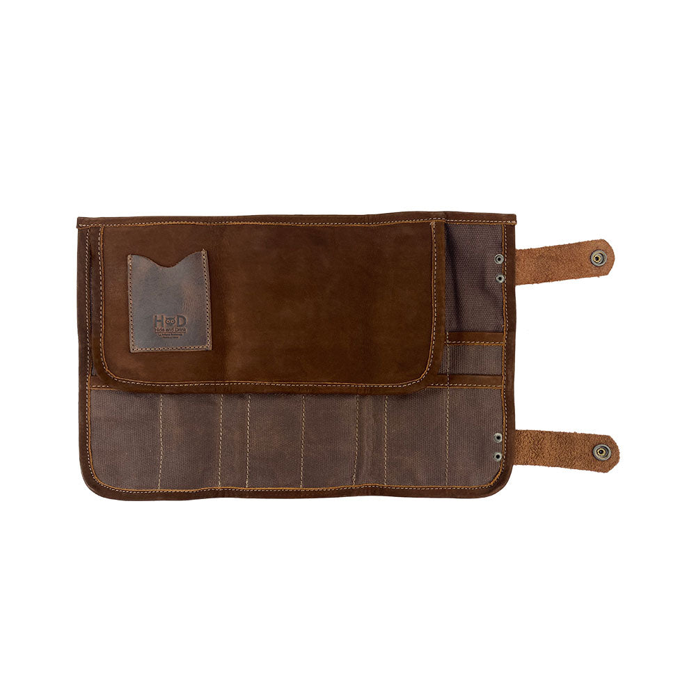 Hide & Drink's Barber Tool Roll showcases a Snap Tool Roll Up Bag with 14 Slots, perfect for organizing scissors & screwdrivers. This portable carry case, crafted from Full Grain Leather emphasizes StockyardX's small batch production approach and artisan craftsmanship, hand cut, hand sewn, and fire branded in La Antigua Guatemala & Oaxaca Mexico.