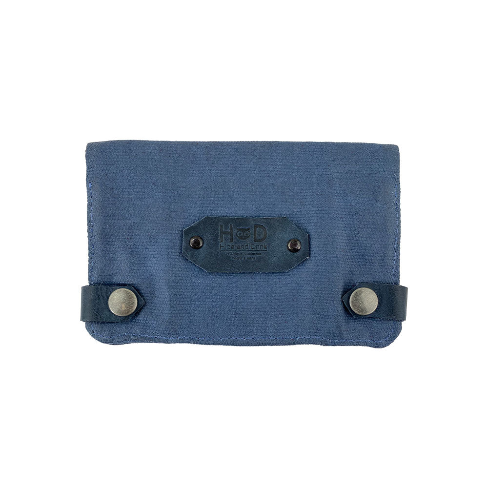 Front view of the blue Hide & Drink Tobacco Pouch Waxed Canvas with snap closures. This travel essential doubles as a stylish tobacco pouch and field notes case, highlighting the artisan craftsmanship from La Antigua Guatemala.